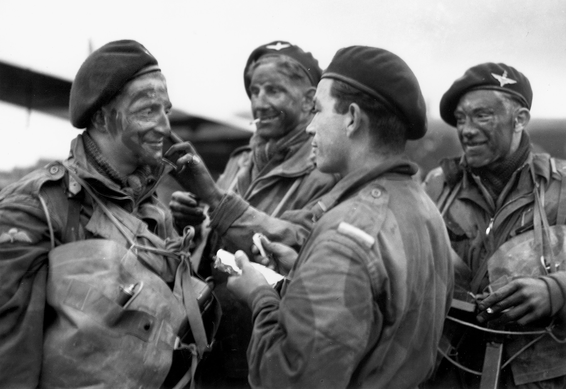 British airborne troops apply lampblack to their faces before boarding their gliders and transports on the evening of June 5. 