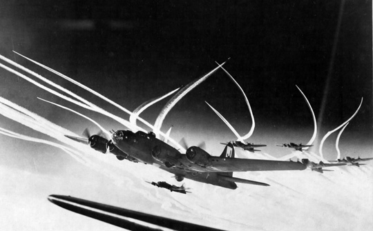 Vapor trails thatch the skies as Boeing B-17 Flying Fortress bombers of the 390th Bomb Group and their escorting fighters maneuver during a raid on the city of Emden, Germany, on September 27, 1943. Just days later, the the 390th Bomb Group participated in the costly raid on Münster.