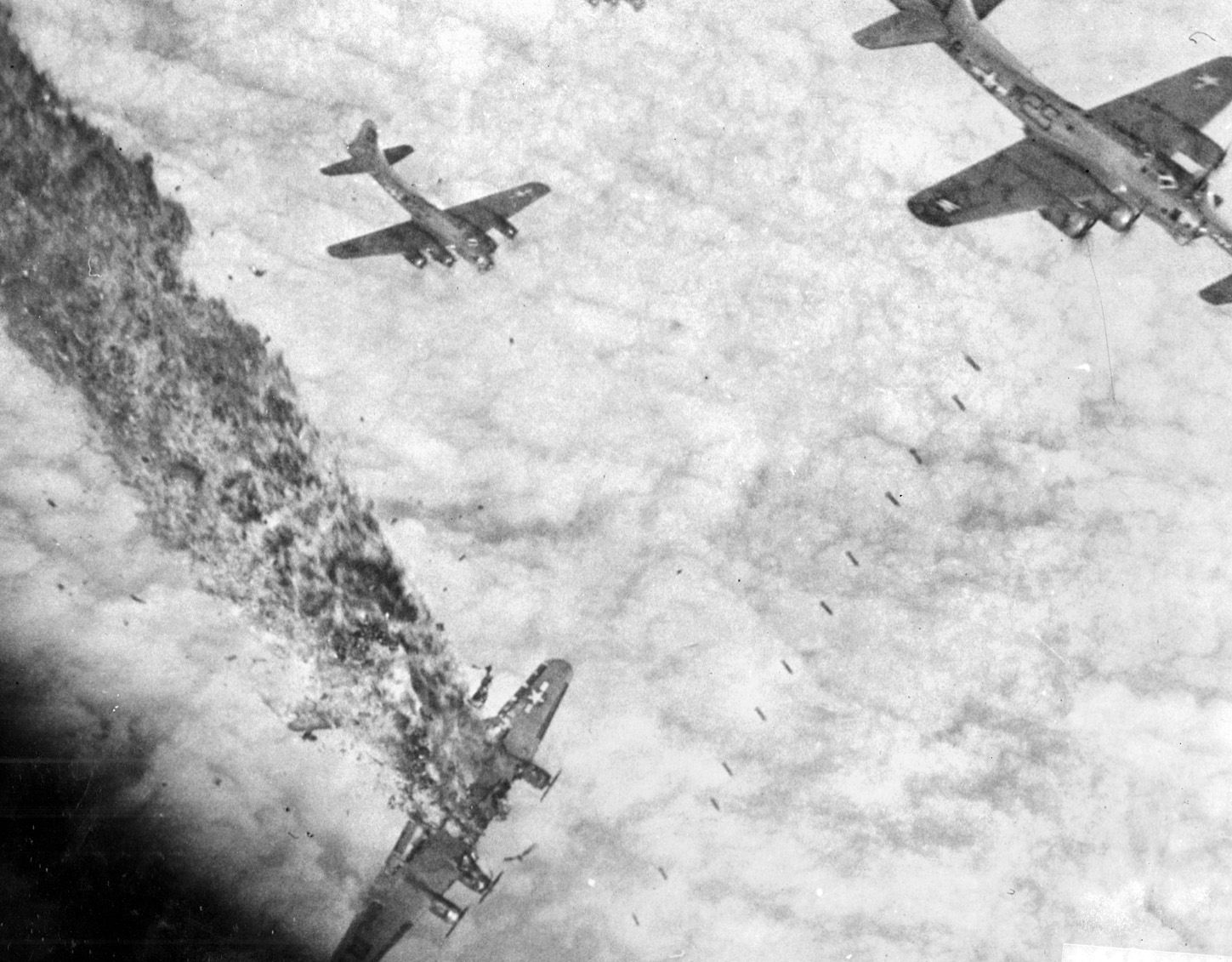 This horrific image depicts the death throes of a B-17 bomber shot down over Germany.  The aircraft took a direct hit from enemy fire, blowing the nose off the plane with the pilot, co-pilot, navigator, and bombardier trapped inside.