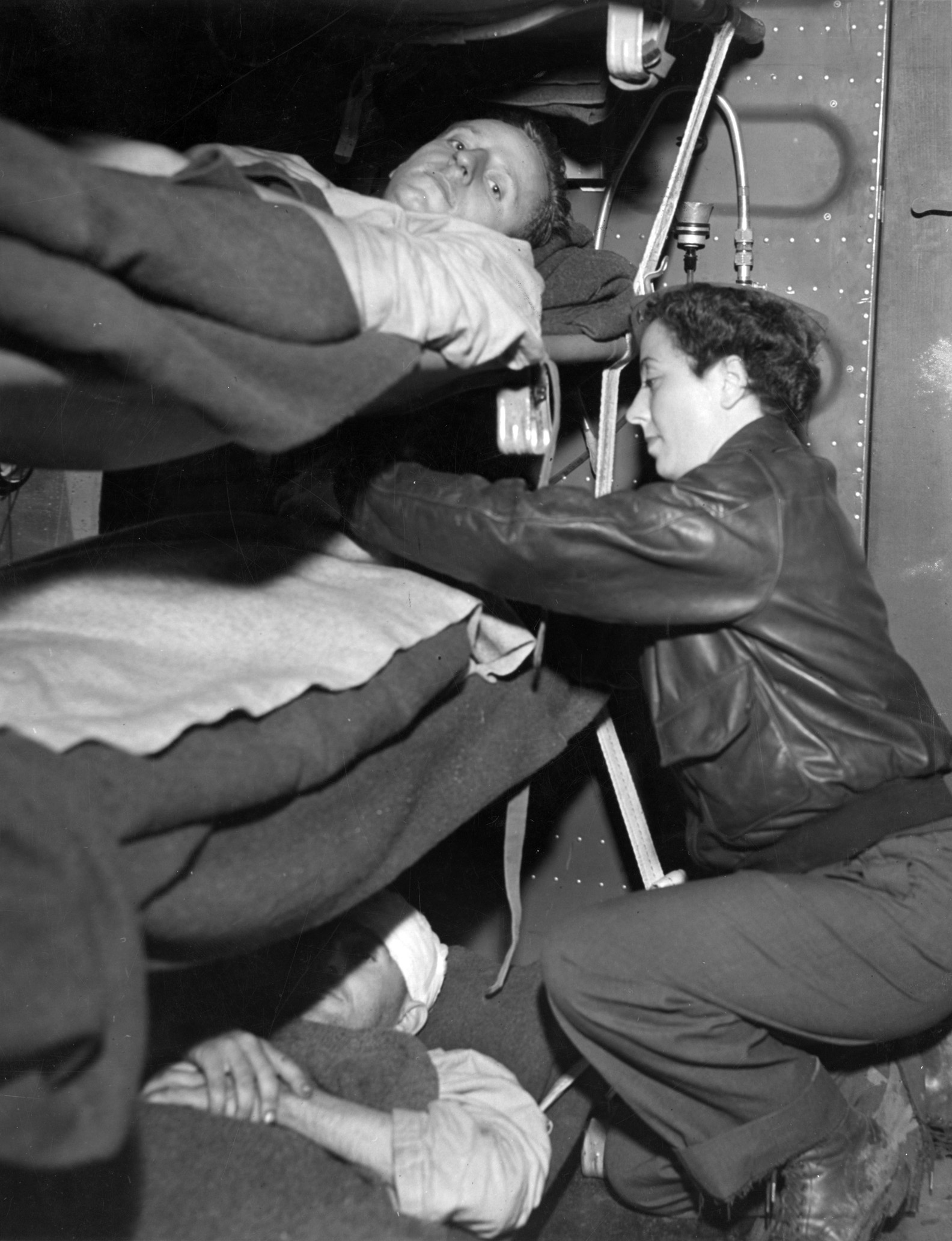 Army nurse 2nd Lieutenant Katherine Friedrich attends to a wounded patient aboard a Douglas C-47 transport aircraft bound for Britain.  The evacuation plane had taken off from Toul, France, where Allied soldiers who were wounded in combat or ill were prepared for the flight.