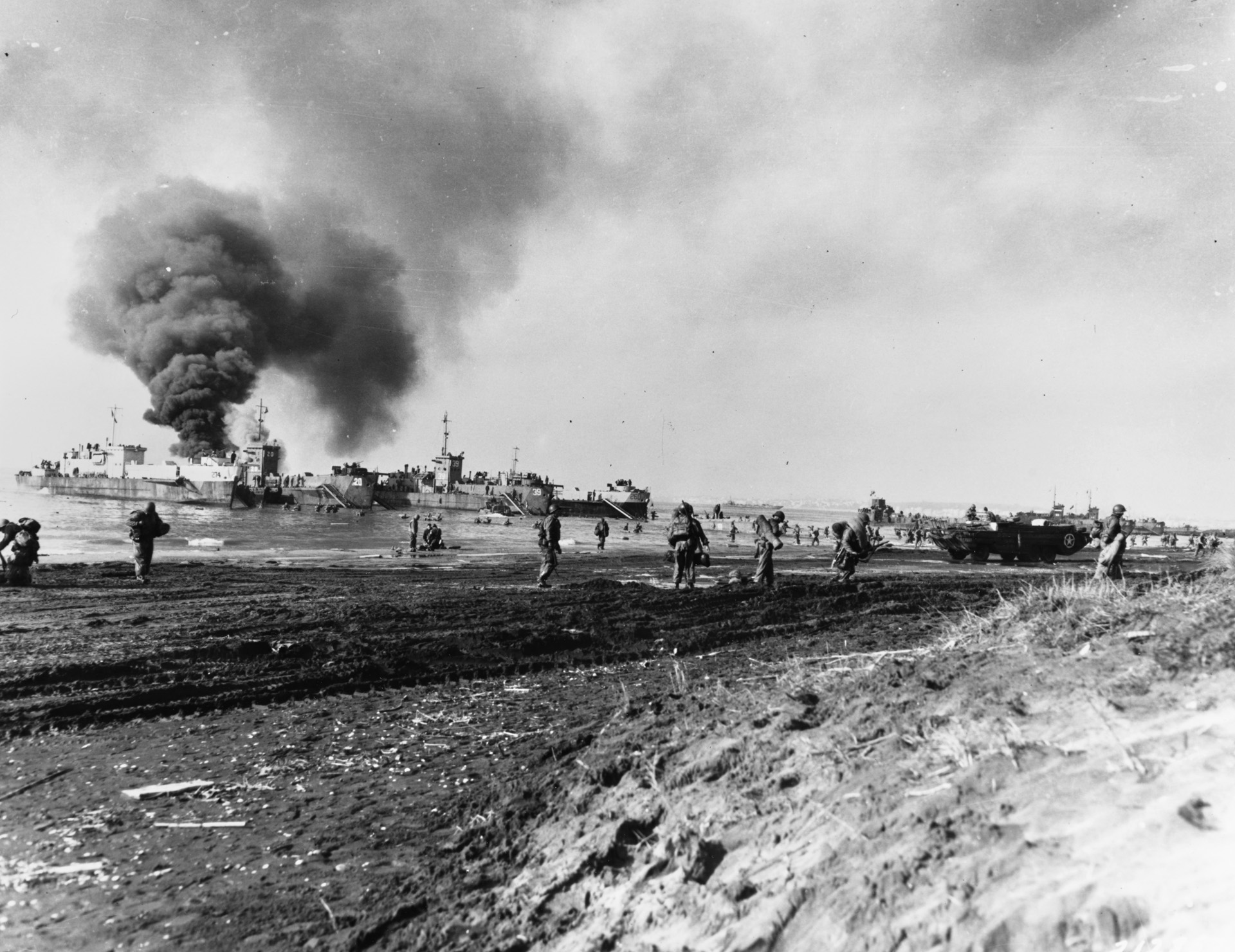 American troops land at Anzio on January 22, 1941, against light enemy resistance. The Luftwaffe did make an appearance and scored a hit on a supply ship, which burns in the background. 