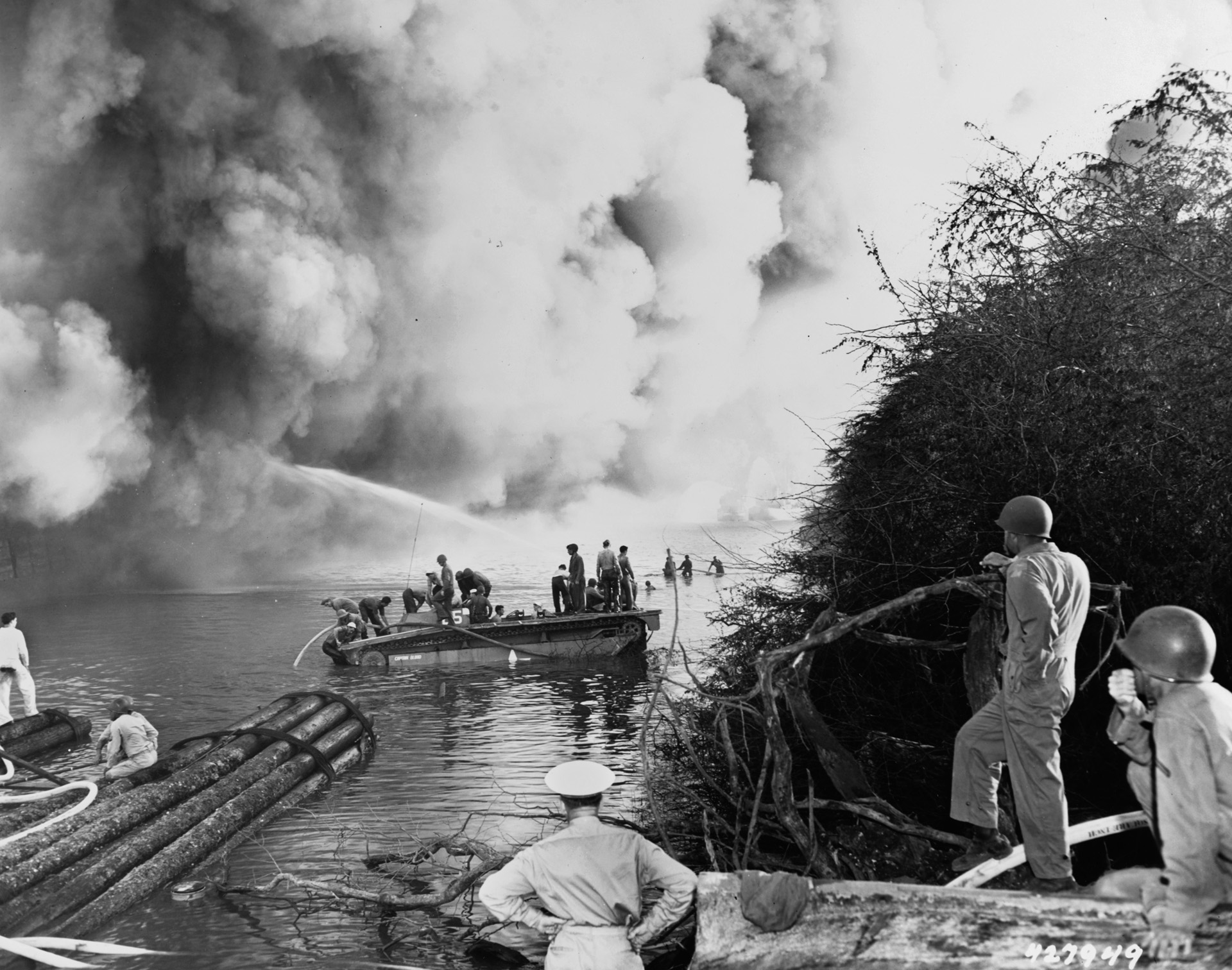 During the evening of May 21-22, 1944, sailors manning fireboats battle the flames aboard LSTs in Pearl Harbor’s West Loch. The horrific destruction probably was initiated by the careless securing of combustible materials combined with smoking.