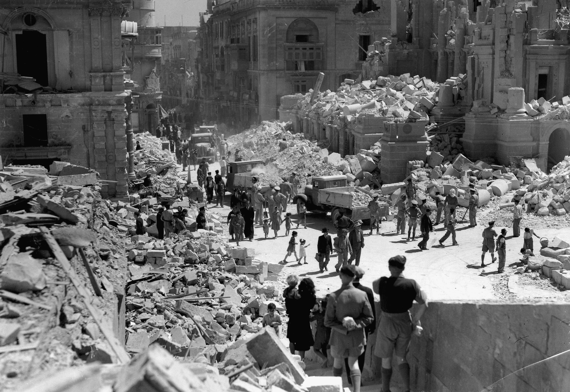 Civilians and military personnel walk through the devastated streets of a Maltese town. At times, the capabilities of British forces to defend the island were nearly decimated.