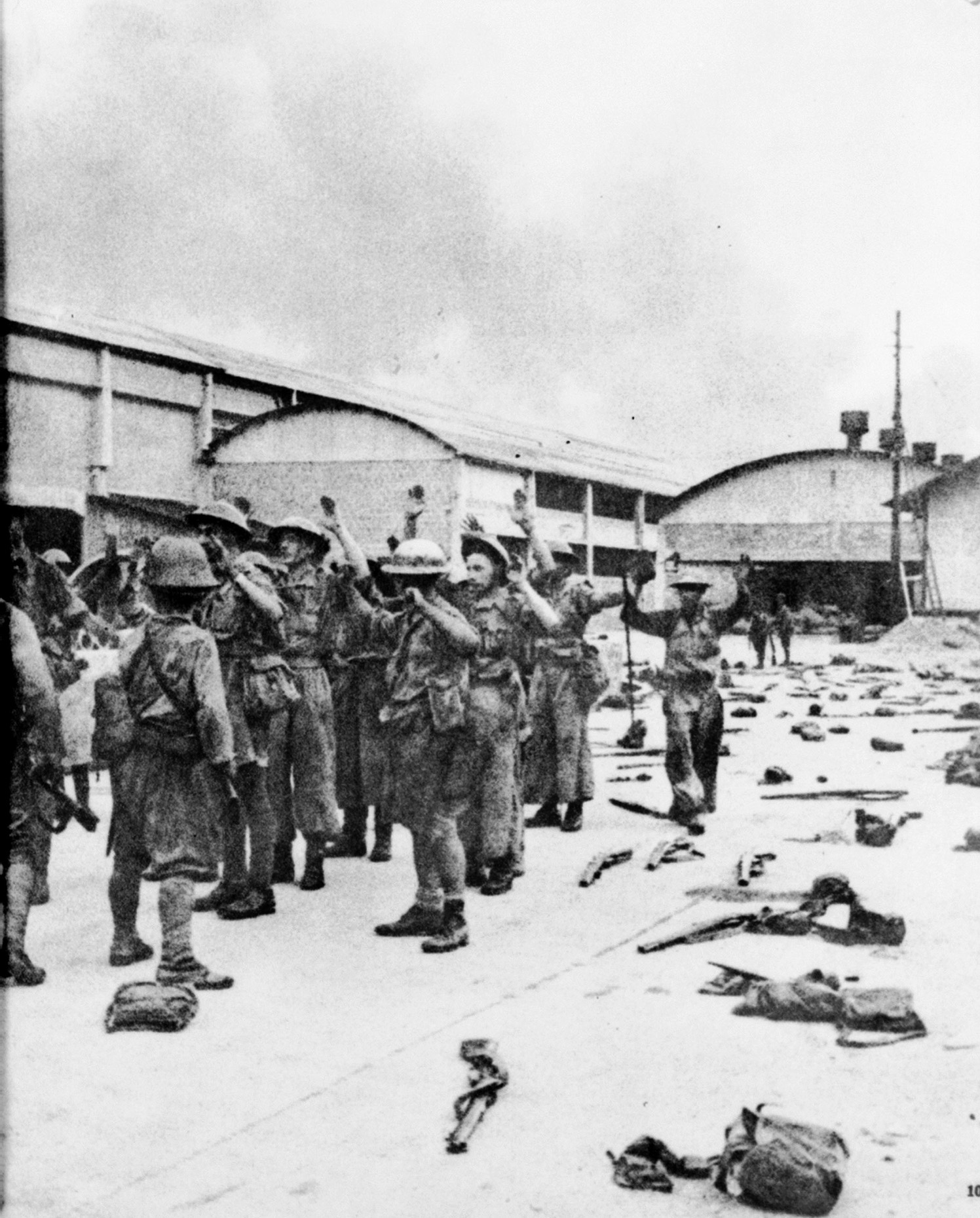 After their ignominious surrender at Singapore, British soldiers, their hands raised above their heads, are marched off into wretched captivity. Many of them did not survive, while others endured four years of harsh treatment at the hands of their Japanese captors.