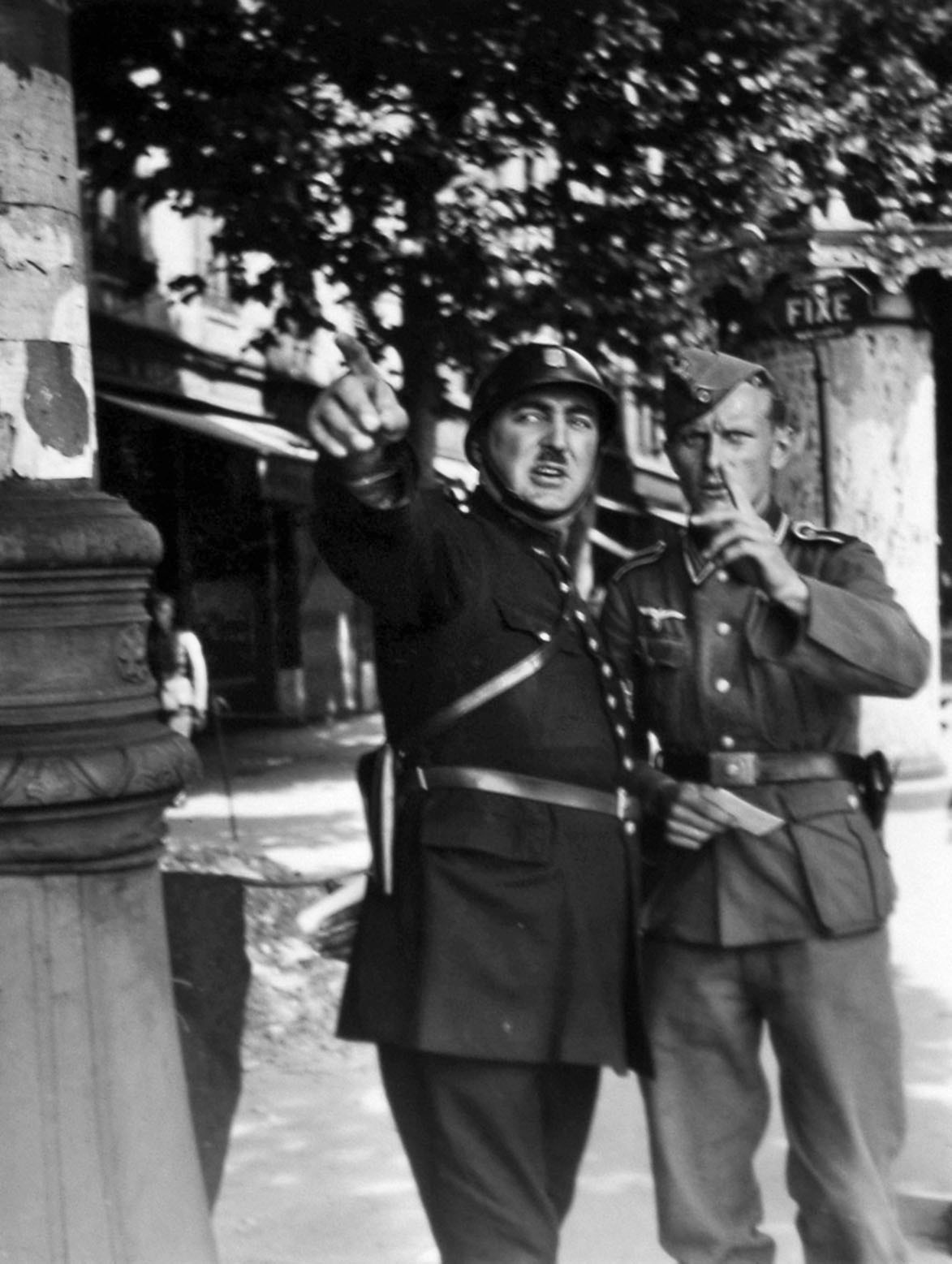 A German NCO in Paris gets directions from a gendarme. German soldiers were ordered to be on their best behavior in Paris, the comfortable posting most sought after, especially after the war on the Eastern Front began. Many Germans had visited France prior to the Nazi era as welcomed tourists. As occupiers, they found the French, in great part, accommodating. 