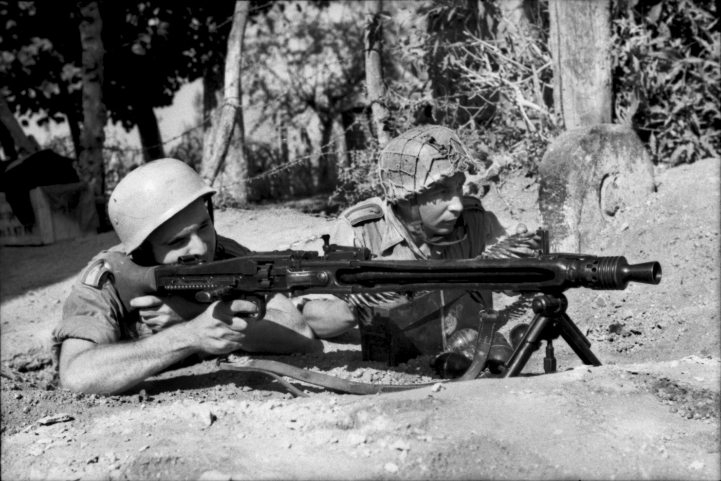 German paratroopers fire an MG 42. The Germans typically deployed the superb weapon in concealed positions so as to enfilade attacking enemy units.