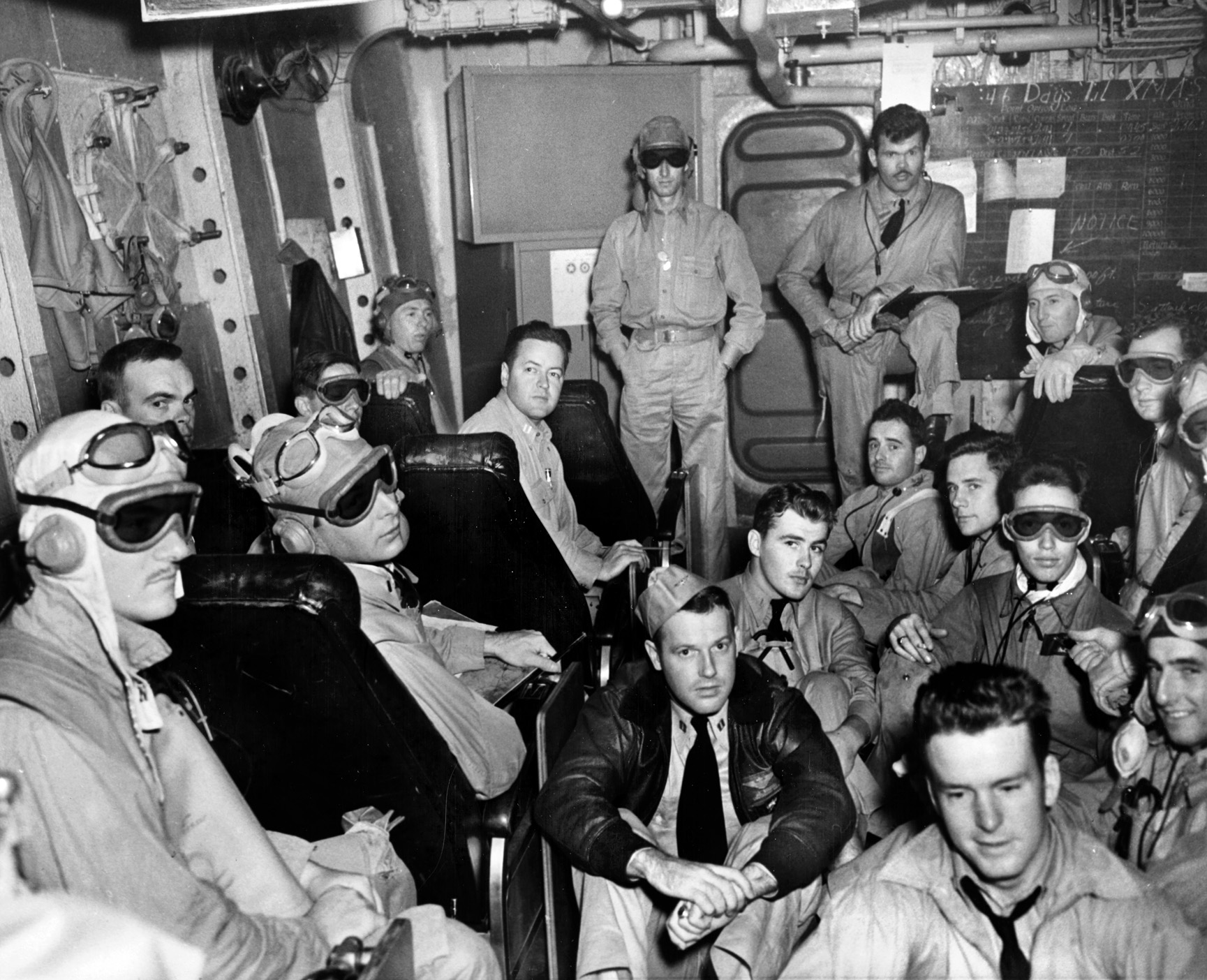 Fighter pilots gather in a ready room of Ranger in the early morning hours of the first day of Operation Torch. Pilots scheduled to take off before dawn wear dark goggles to become accustomed to the darkness. 