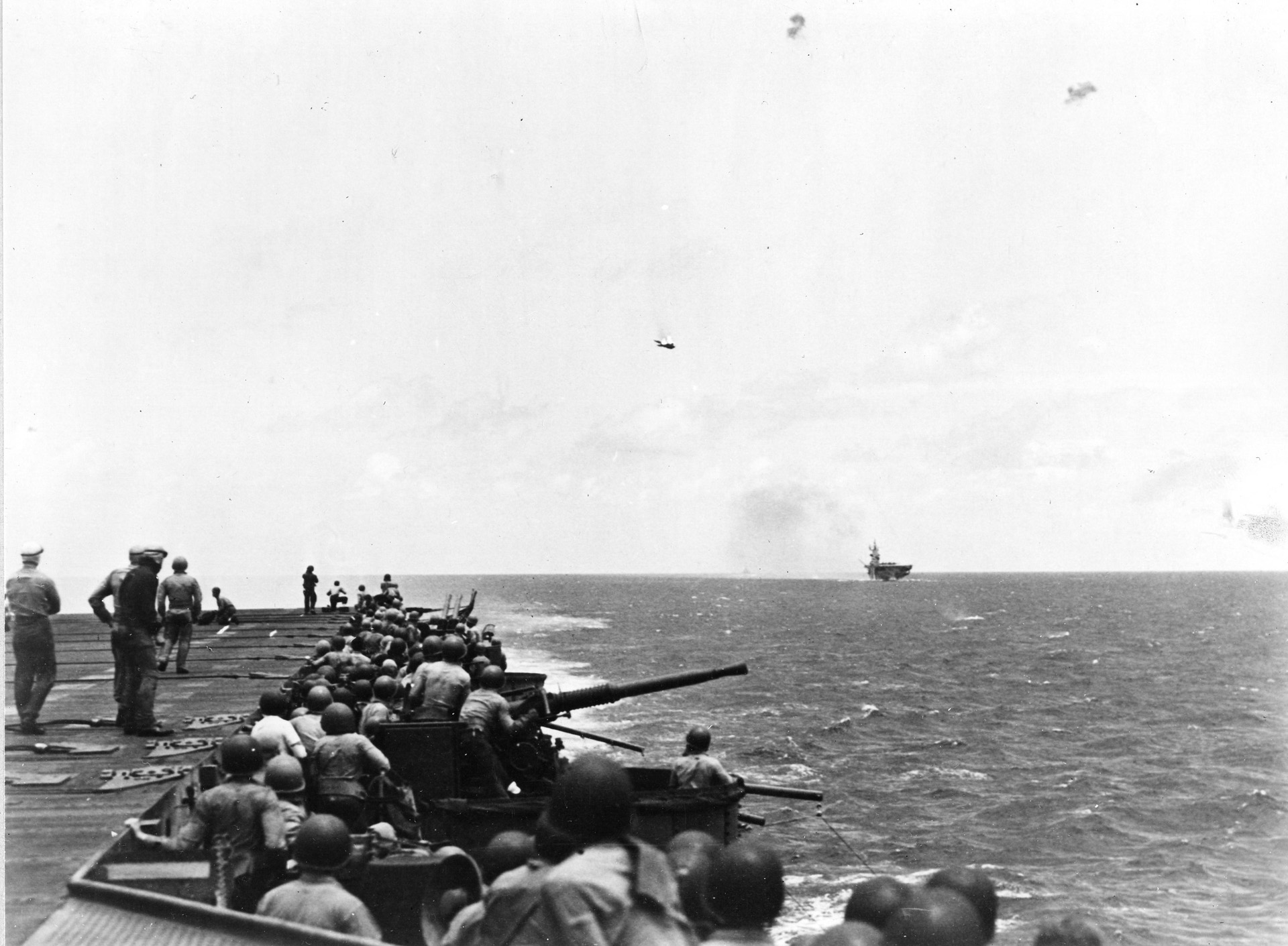 Navy gunners on board the USS Bunker Hill and USS Cabot shoot down a Japanese plane with antiaircraft fire. 