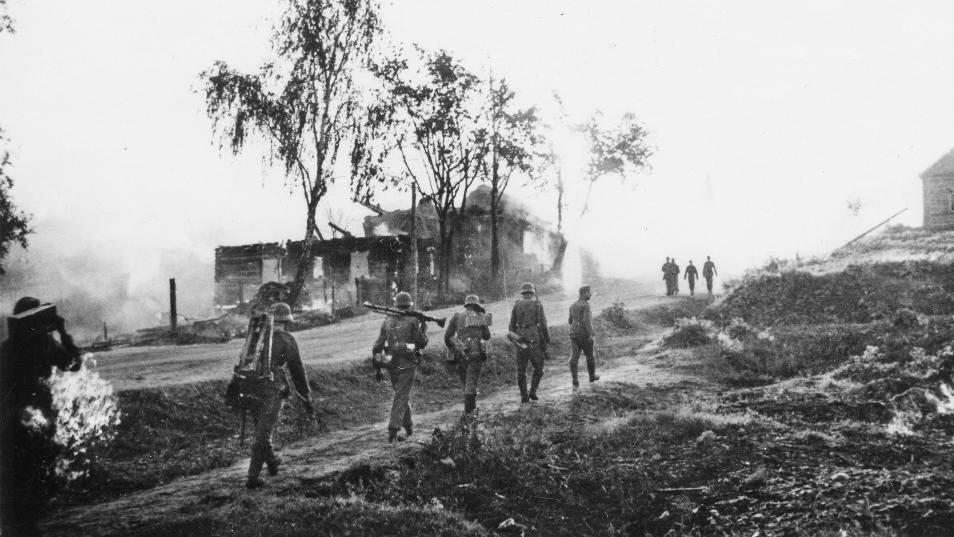 A line of German soldiers marches past a burning Russian building somewhere on the Eastern Front. The vast spaces of the USSR swallowed German armies and led to mass casualties. Few German POWs lived to return home.