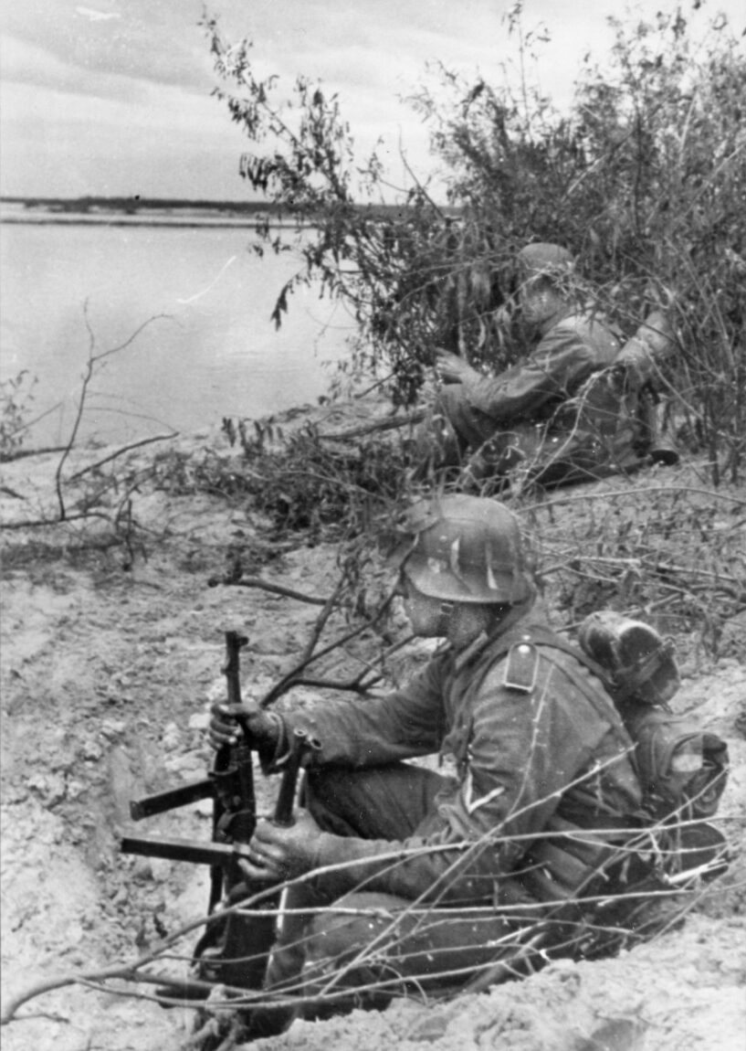 Two German soldiers, the one in the foreground holding two MP40 machine pistols, on sentry duty along an unidentified river inside the Soviet Union during Operation Barbarossa, Hitler’s June 1941 invasion. The invading troops made spectacular progress until Red Army resistance stiffened a few miles west of Moscow. Lubbeck’s unit advanced as far as Leningrad.