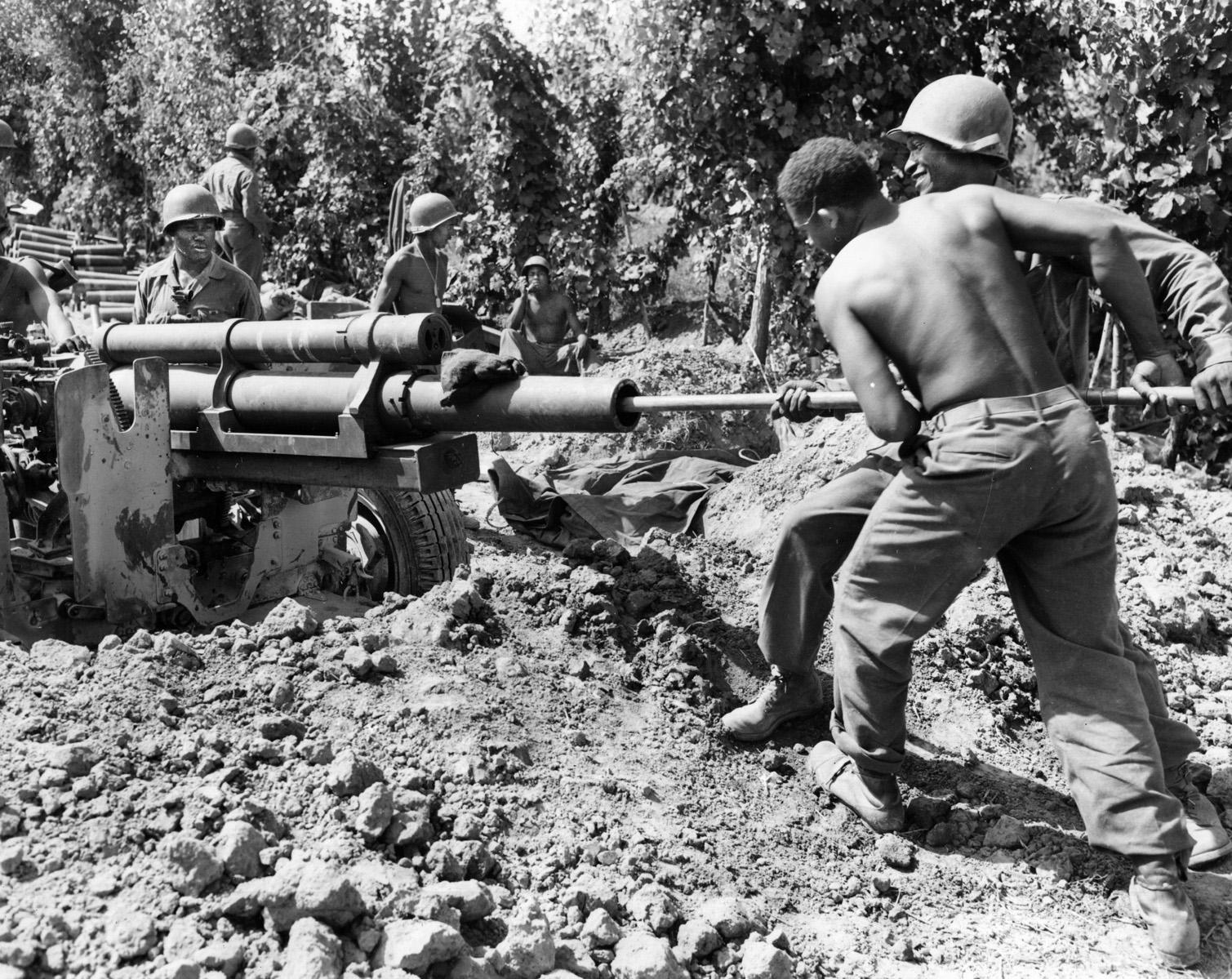 In action on the banks of the Arno River on September 1, 1944, the crew of a 105mm howitzer of Battery B, 598th Field Artillery, services its weapon. The 598th was a component of the 92nd Infantry Division.