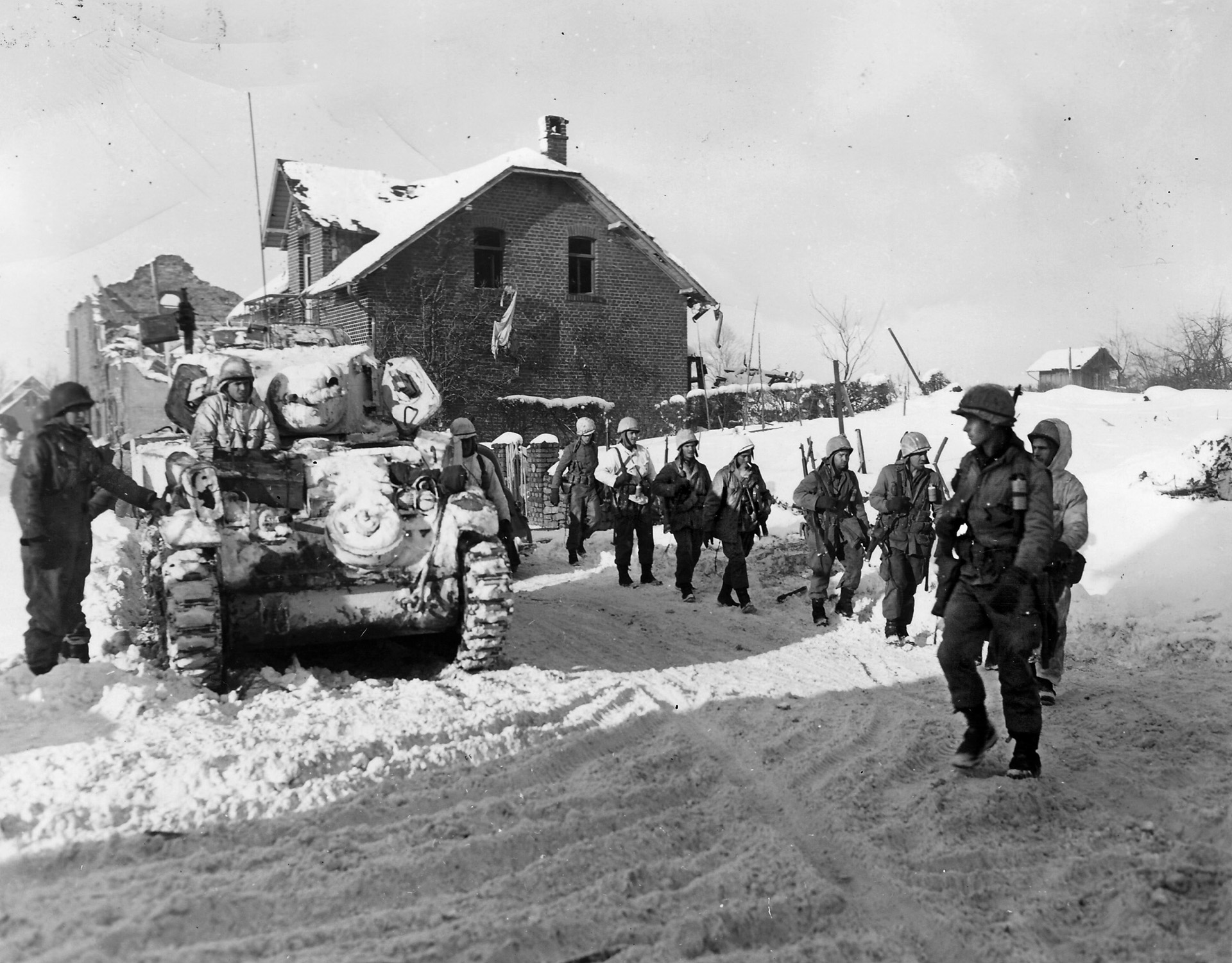 Troopers of the 509th Parachute Infantry Regiment, 82nd Airborne Division, trudge past an M5A Stuart light tank during fighting around the French village of St. With. The 509th suffered 49 casualties at Parker’s Crossroads.