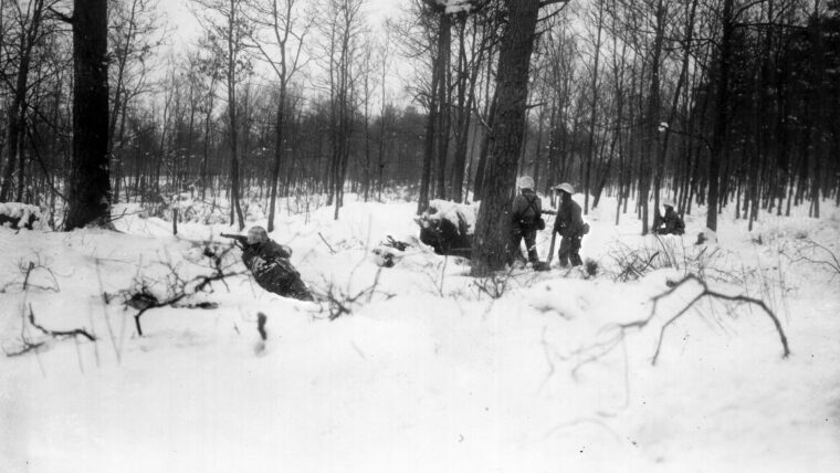 Soldiers of the U.S. 106th Infantry Division come under sporadic German fire during fighting in the Ardennes Forest.