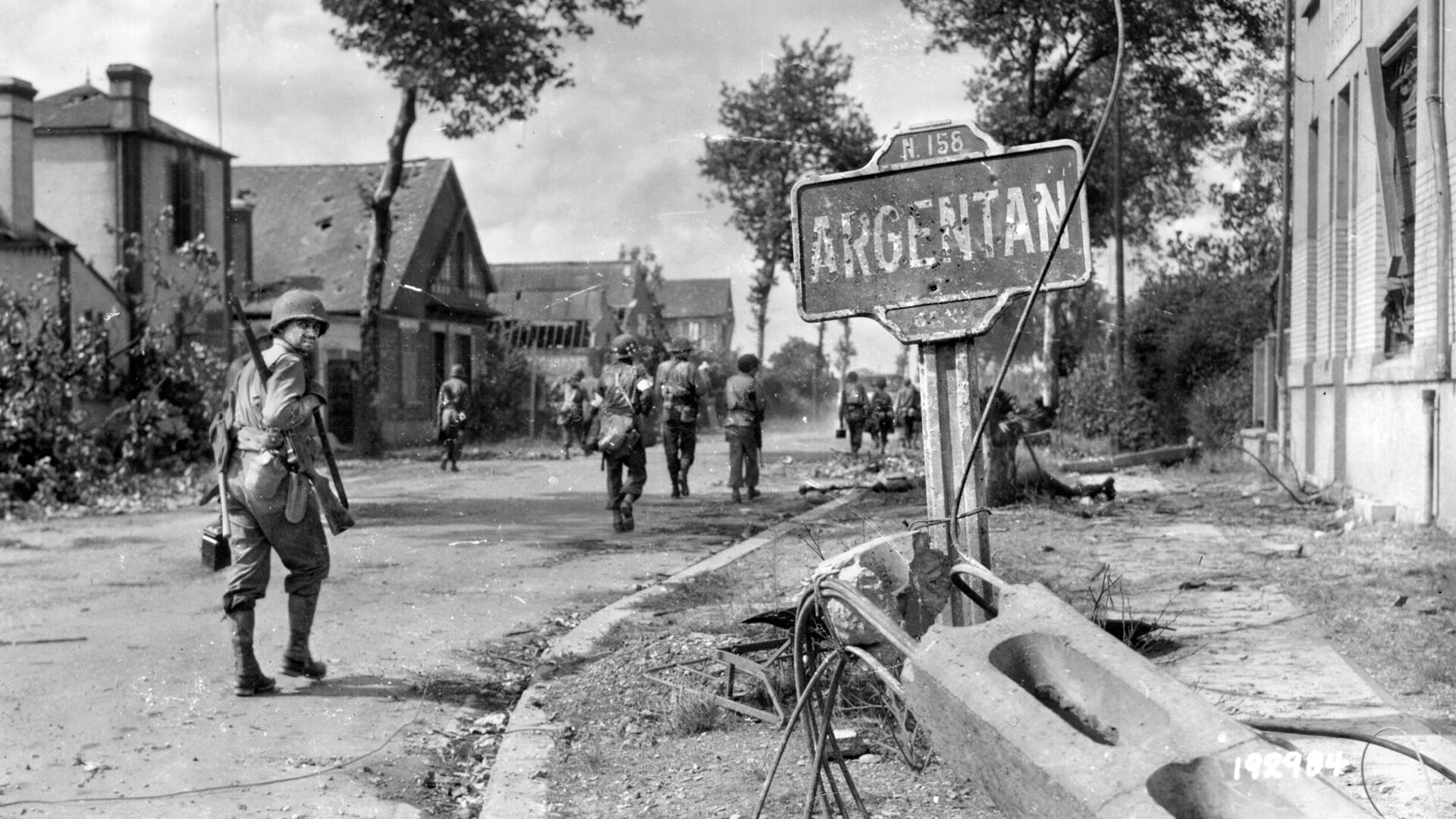 American infantrymen enter the war-ravaged French town of Argentan during the effort to trap thousands of retreating German troops in the Falaise Pocket during the final stages of the Normandy Campaign in 1944. The fighting around Argentan was the baptism of fire for the U.S. 80th Infantry Division.