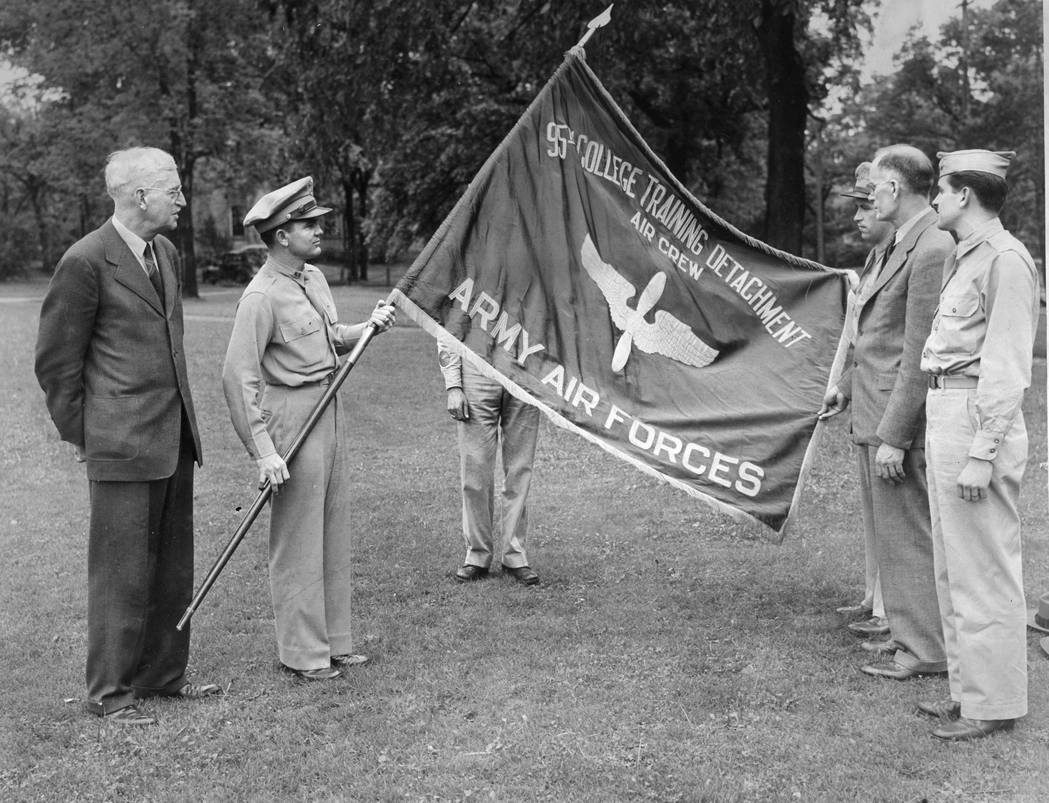 Captain Charles R. Manning, commanding the 95th CTD at Beloit, holds the flag for staff members and school administrators to admire. Beloit College was one of 150 schools nationwide that hosted the Army Air Force (AAF) Aviation Cadet Training Program.