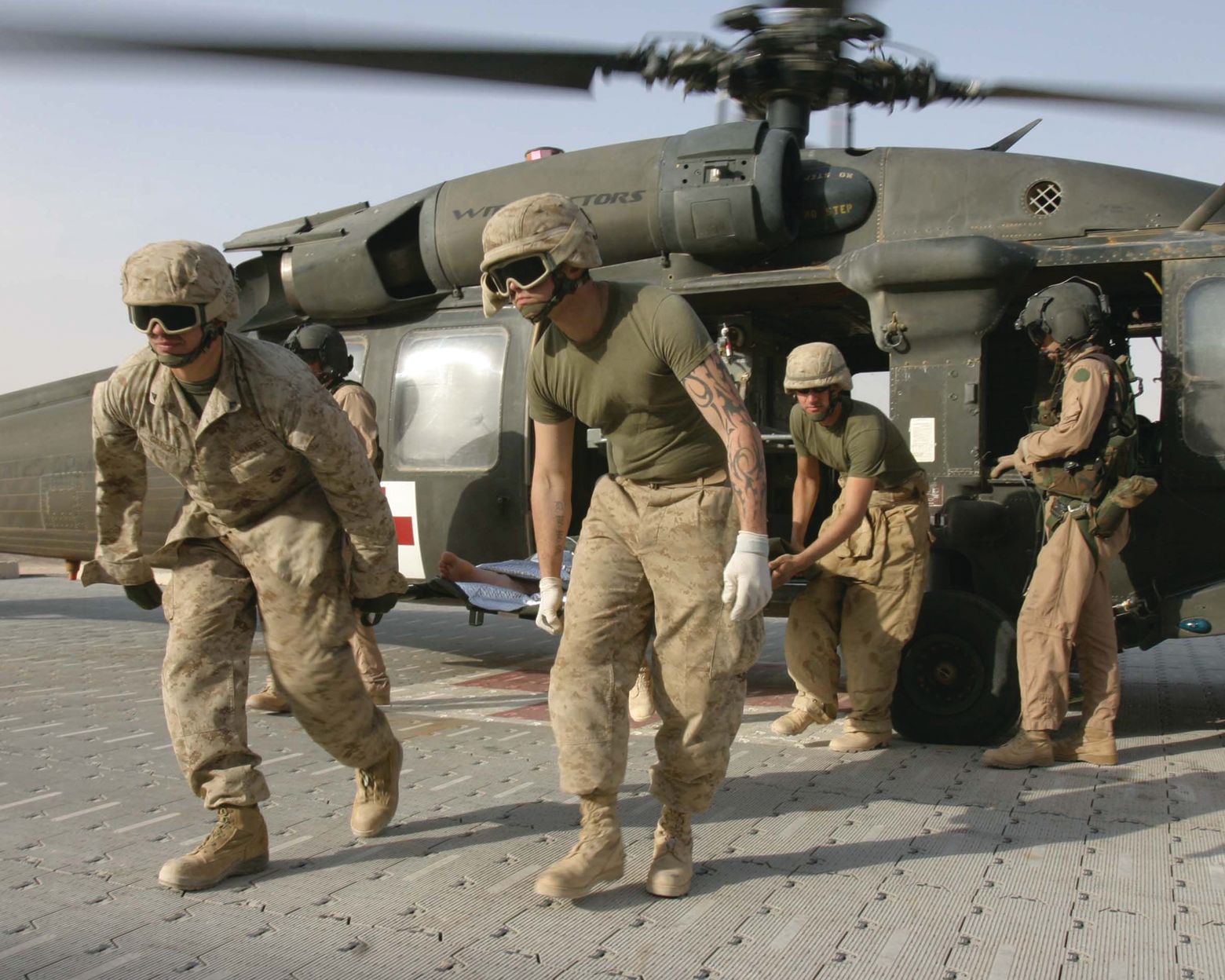 U.S. Marines unload a wounded fellow Marine from an Army UH-60 Blackhawk helicopter at Al Qaim, Iraq, in 2005.