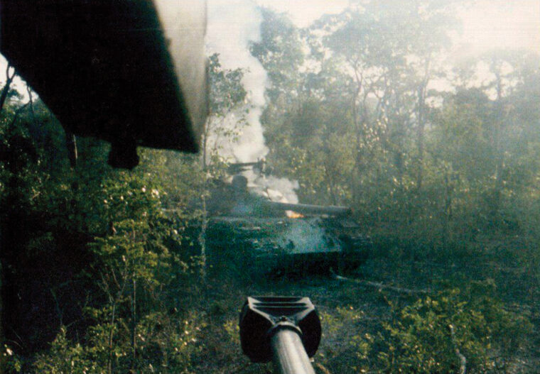 View of a burned-out enemy tank from the turret of a Ratel 90 of the South African 61 Mechanized Battalion. Although lightly armored, the Ratels were fast and mobile and able to take on Soviet T-55 tanks with their 90mm guns.