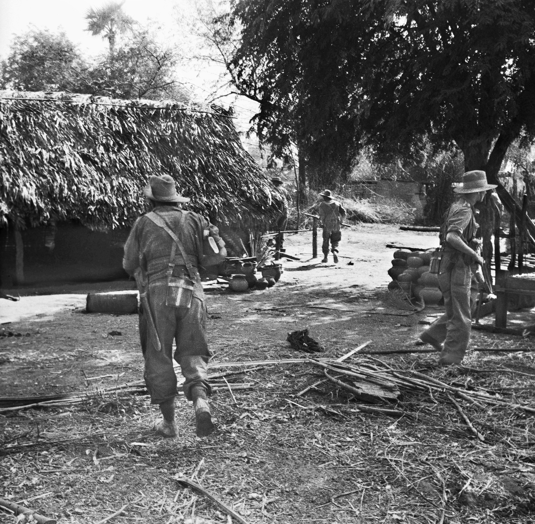 Infantry search village huts on the outskirts of Meiktila. British and Indian forces worked hard to secure areas because the Japanese frequently infiltrated back into the position from which they had been driven out the day before.