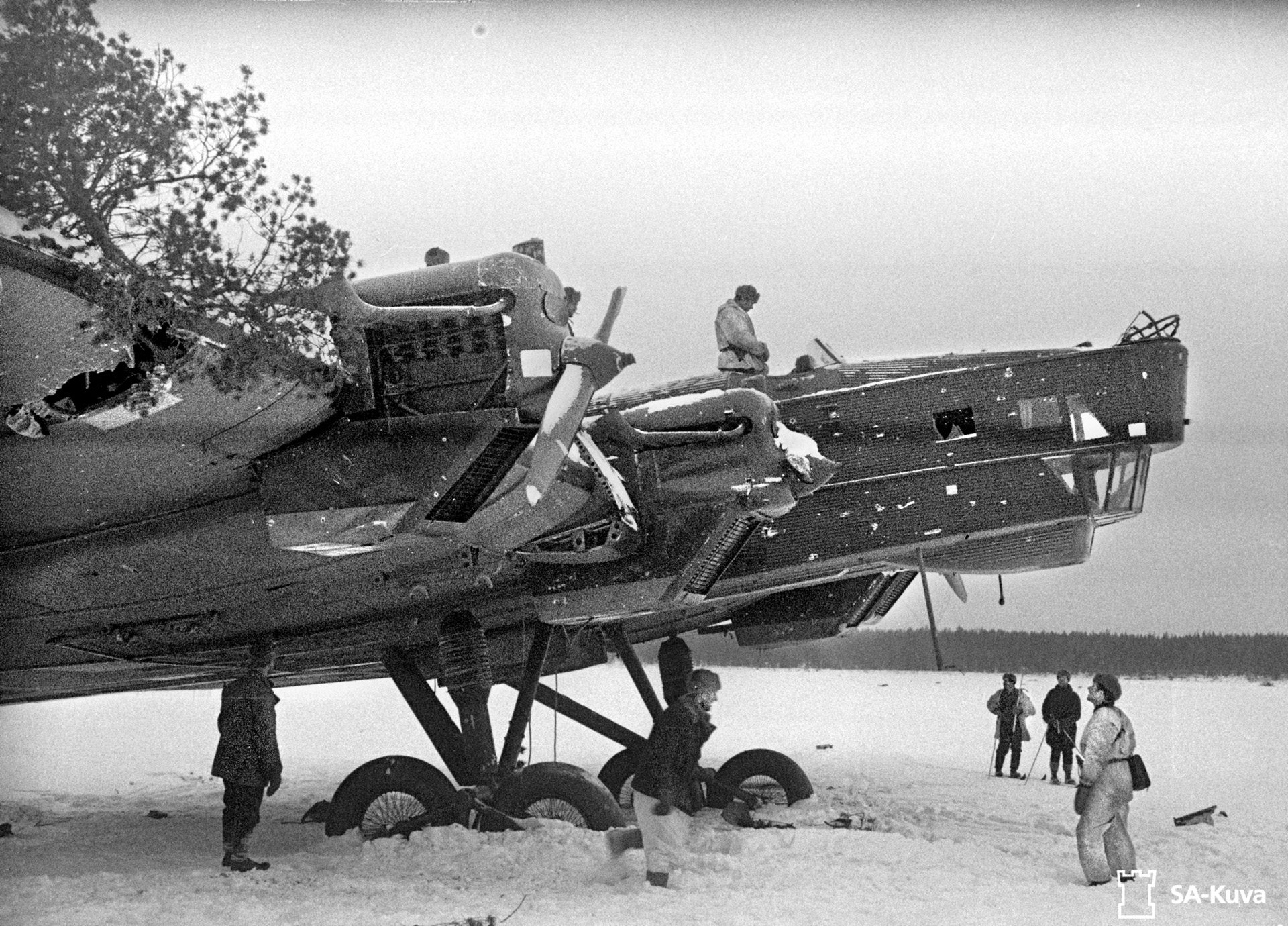 An ungainly, obsolescent Tupolev TB-3 four-engine heavy bomber comes to an ignominious end after crash-landing on a frozen lake and being destroyed by a grenade launcher.