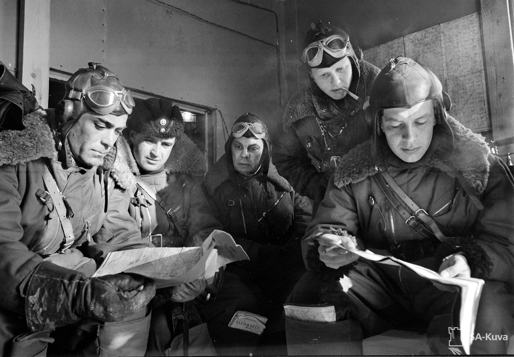 Prior to a mission, Finnish pilots study an aerial chart at their base at Pyhäniemi Manor, a historic home that served as the headquarters for a squadron. 