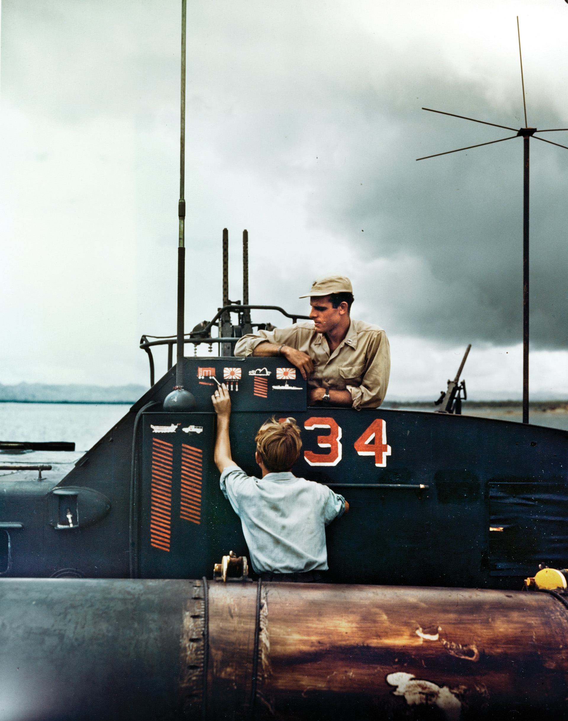 Although badly outnumbered, PT boats based at Tulagi played an important role in the effort to halt the Japanese from evacuating thier men. Here, a Navy crewman paints the symbol for a kill on his boat’s bridge.