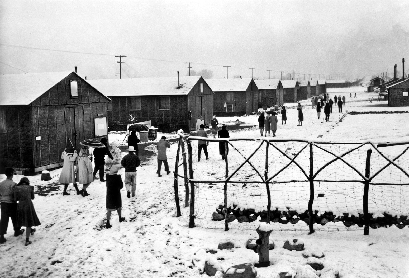 The Manzanar Relocation Center in California’s high desert, between Fresno and Death Valley, held over 11,000 internees, mostly from Los Angeles, at its height. Here, Japanese Americans walk through the camp on a snowy winter day in 1943. 