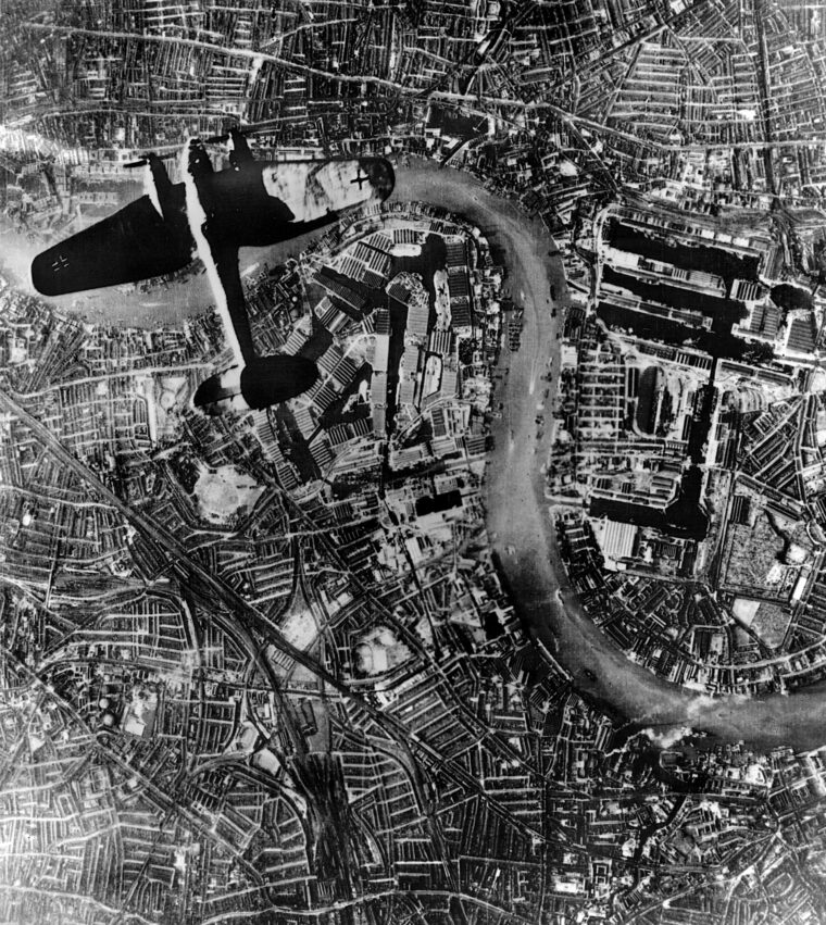 A Heinkel He 111 bomber flies over the Thames River and the East End Docklands area at the beginning of German evening raids, September 7, 1940—the first of eight months of such raids that Hitler used to try to bomb Britain into submission. Some 40,000 Londoners died during the raids.