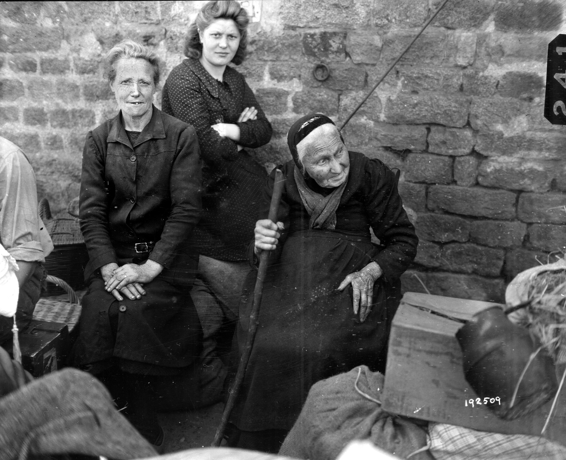 Civilians always seem to be caught in the middle during a war. Here, three women are photographed after they returned home to Mortain once the battle had ended. Townsfolk provided food, water, and other help for the beleagured GIs.