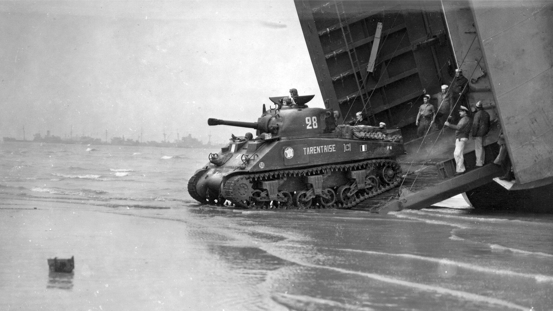 A Sherman tank of the 2nd French Armored Division exits an LST (Landing Ship, Tank) onto Utah Beach, August 4, 1944, and prepares to go into action against the Germans. The unit reached Paris 20 days later.