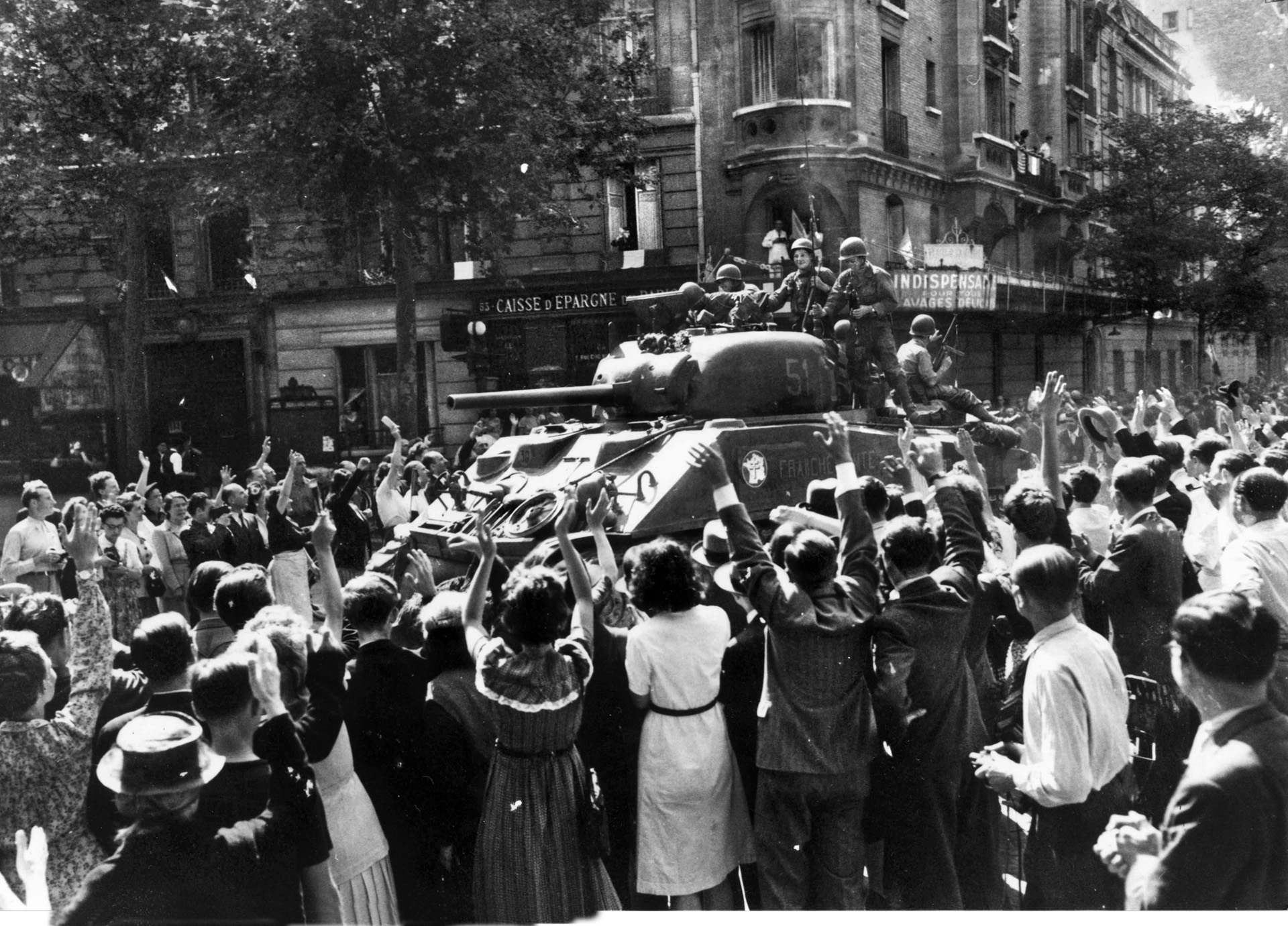 Mobs of Parisians are overjoyed to see Sherman tanks manned by French soldiers. The Allied high command gave the 2nd French Armored Division the honor of being the first troops into Paris. 