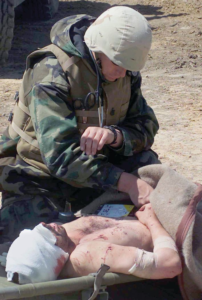 A Navy corpsman takes vital signs on a wounded Iraqi soldier after a firefight outside Numaniyah in April 2003.