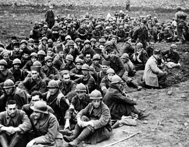 Although there was some resistance encountered from Vichy French forces during Operation Torch, terms of cease-fire were soon reached. In this photo, French prisoners captured while the situation was still unclear sit under guard. Most of these soldiers were soon released. 