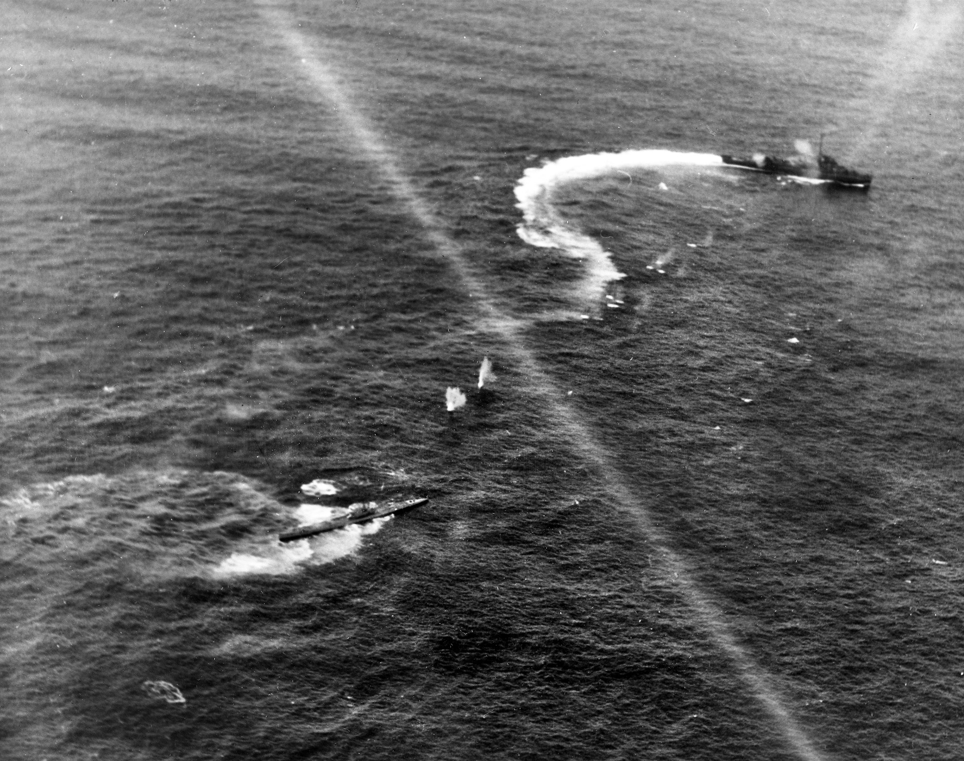 The German submarine U-515 comes under attack by U.S. Navy destroyers and aircraft from the escort carrier USS Guadalcanal. The U-boat was sunk in this action, which occurred in April 1944. 