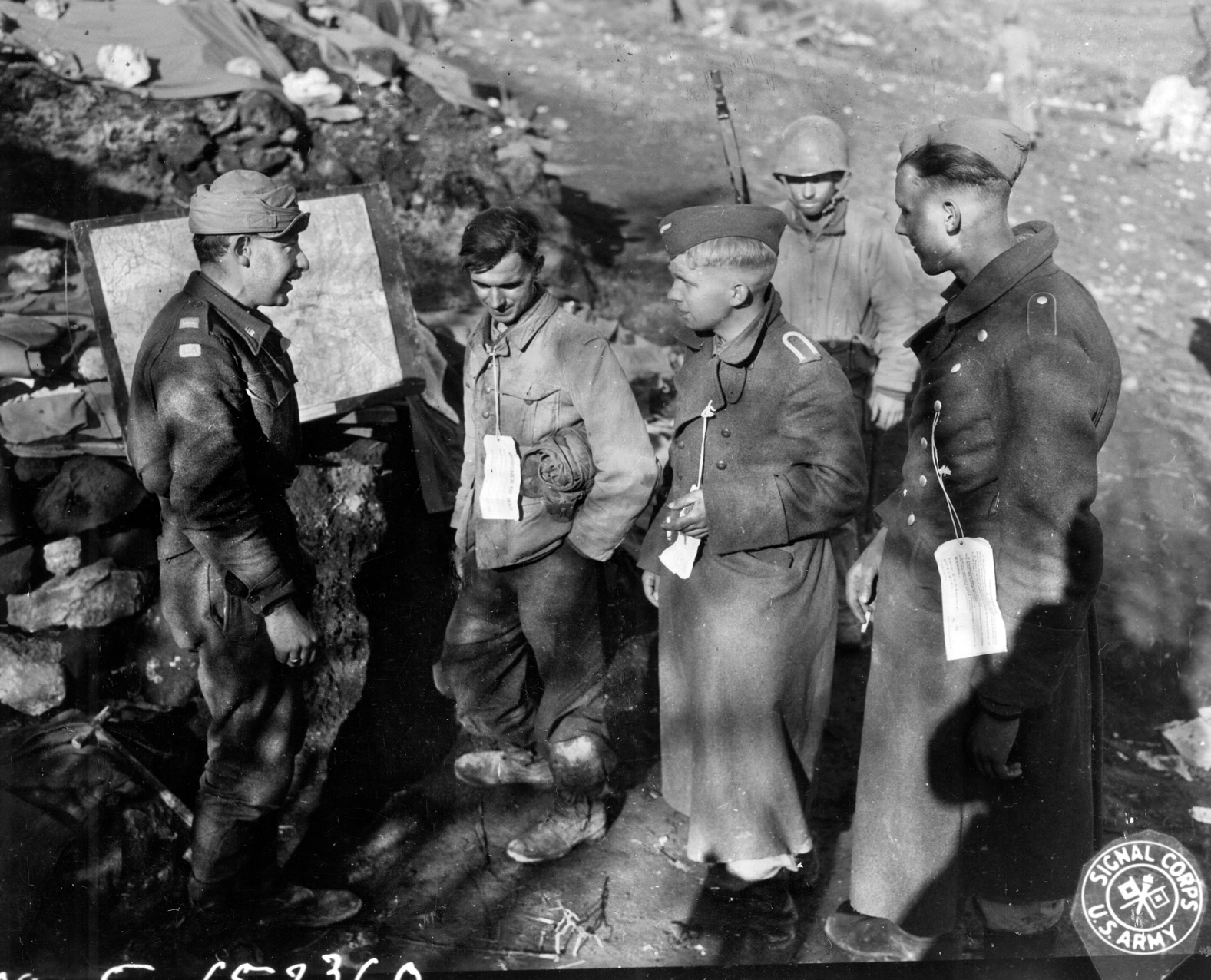 An American officer interrogates young German prisoners from the Hermann Goering Division, recently captured during the fight for Mount Porchia.