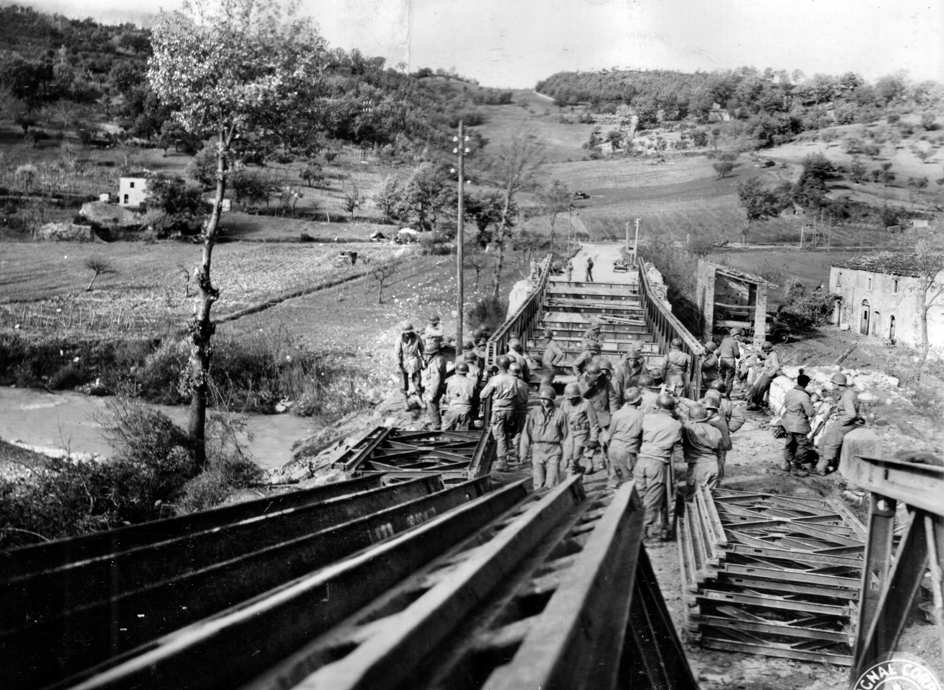 Soldiers of the 48th Engineer Combat Battalion work to repair a bridge and road connection during the Italian campaign. The soldiers of the 48th were later called upon to fight as infantry during the assault on Mount Porchia.