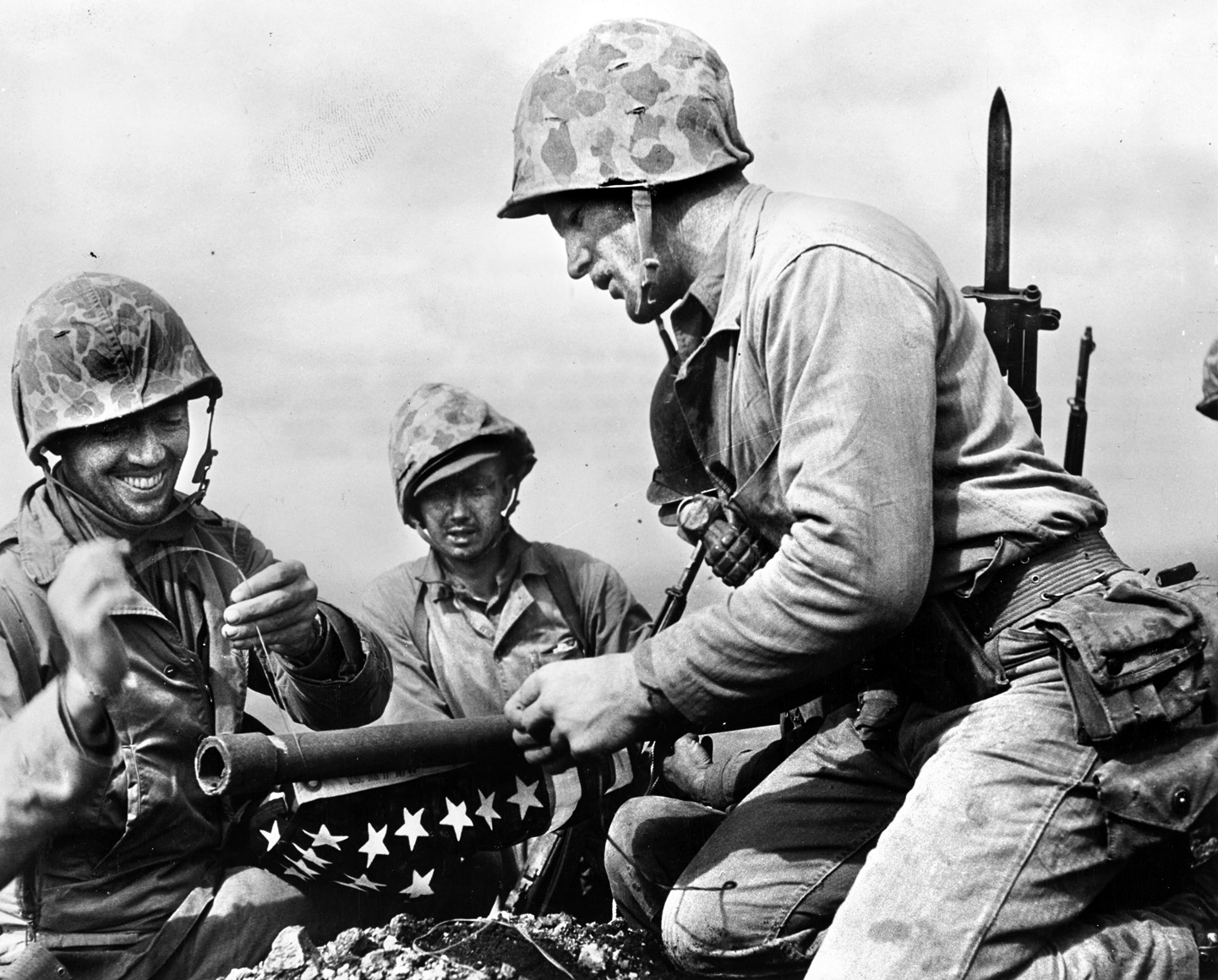 Just prior to the first flag raising on Mount Suribachi, Marines of the 28th Regiment lash the U.S. flag to a length of pipe they located on the summit. The first flag was raised at 10:20 a.m. on February 23, and was followed by the raising of the larger flag made famous in the iconic photo by Joe Rosenthal.