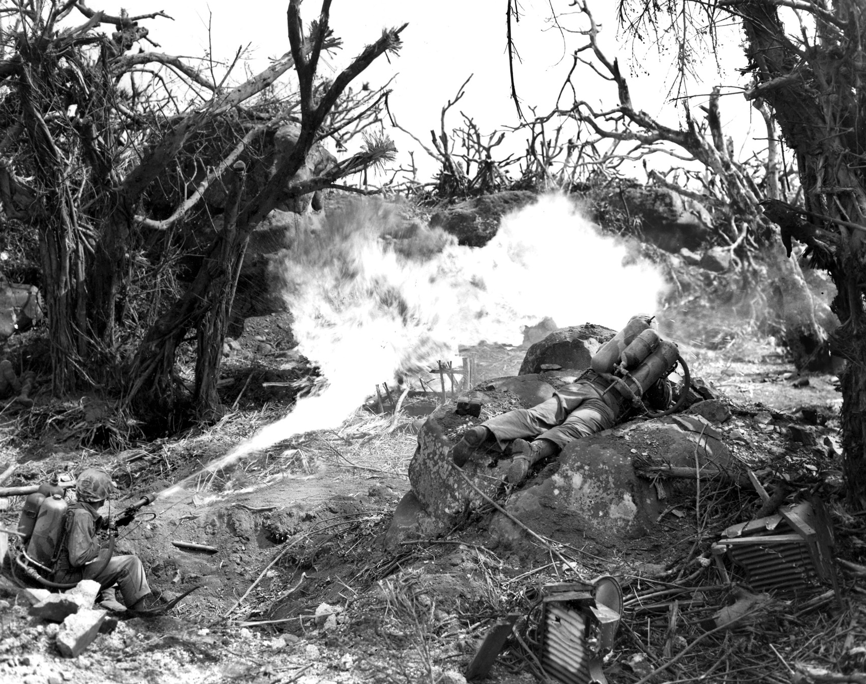 A pair of Marines use a flamethrower to eliminate Japanese troops resisting their advance on Iwo Jima. The Japanese garrison of 25,000 was virtually annihilated during more than a month of fighting, many of the defenders burned out or sealed up in their underground tunnels. 