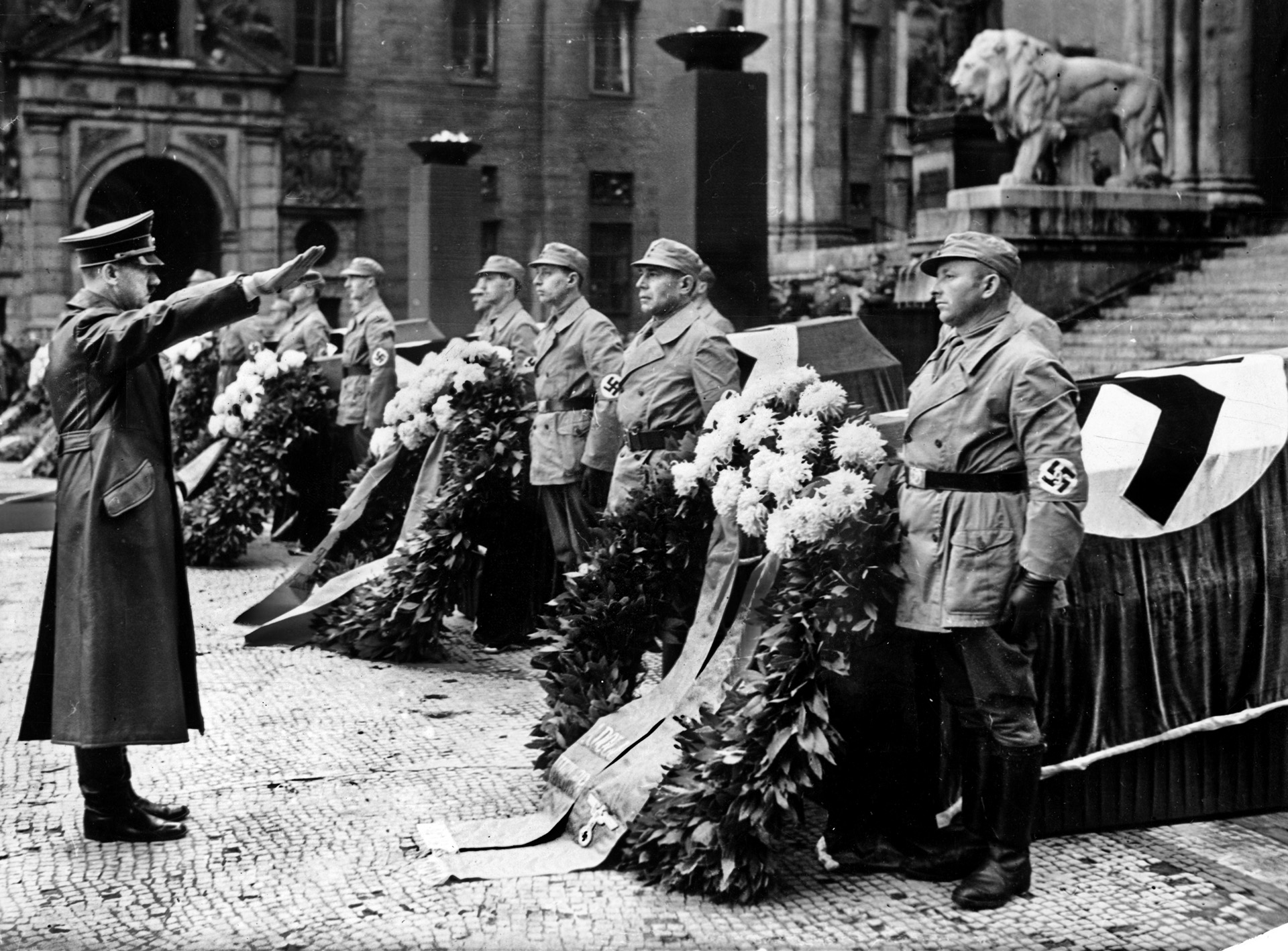 Adolf Hitler gives a stiff Nazi salute to seven men killed in an assassination attempt in Munich during the 1939 anniversary observances of the failed Munich Beer Hall Putsch of 1923.