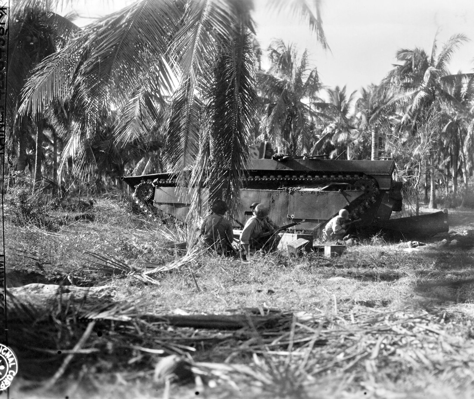 The first wave of the 43rd Infantry Division lands at Lingayen Gulf, Luzon, January 9, 1945, and fires on the enemy from behind their Alligator, officially known as an LVT, for Landing Vehicle. Their seaborne assault was greatly aided by the Marine pilots.