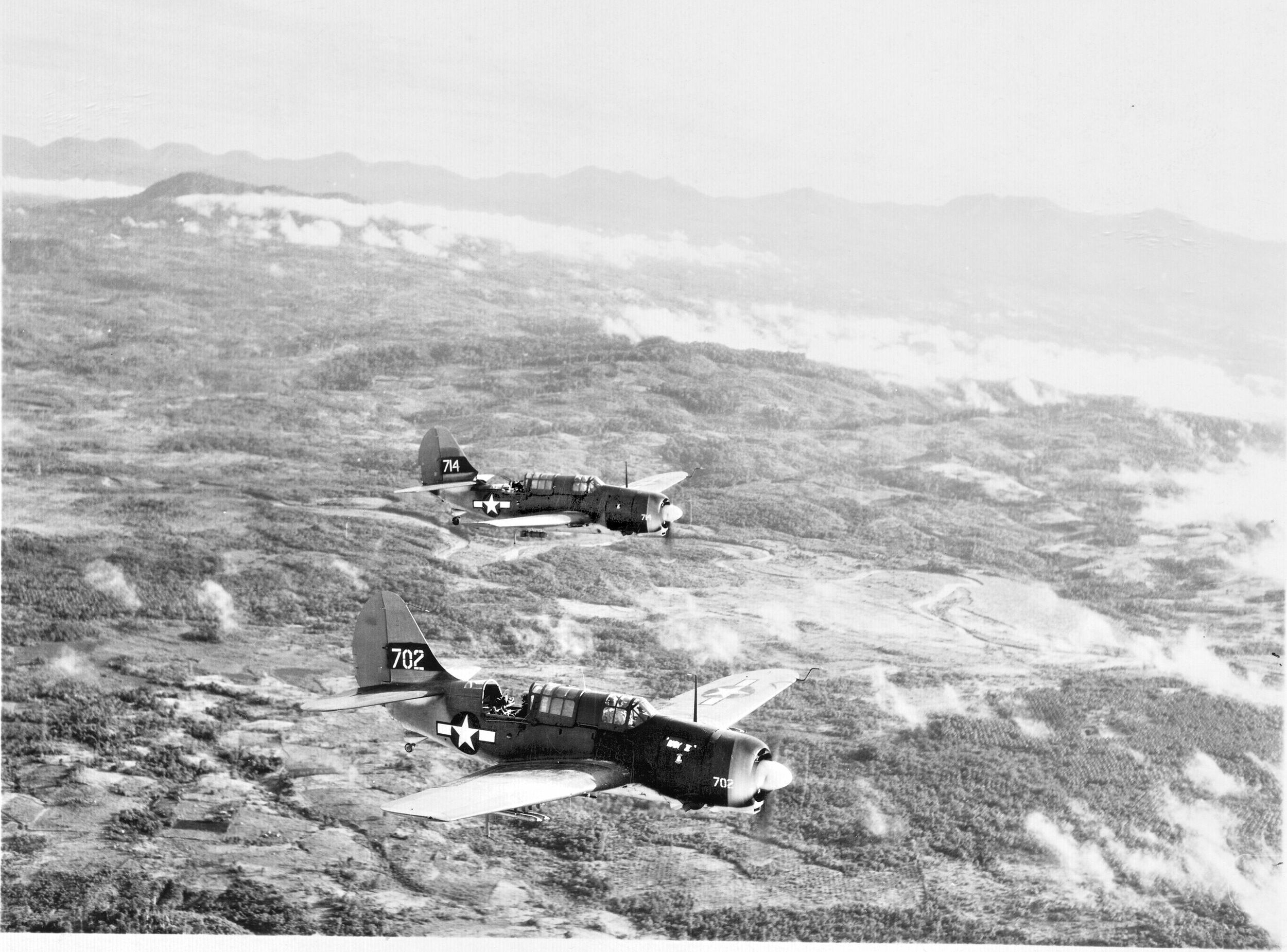 Curtiss SB2Cs (“Helldivers”) of VMSB-244 fly over Mindanao on a close air mission in support of Army ground troops, June 1945. Although not as common as the Dauntlesses and Corsairs, the two-seat SB2Cs packed plenty of precision punch.
