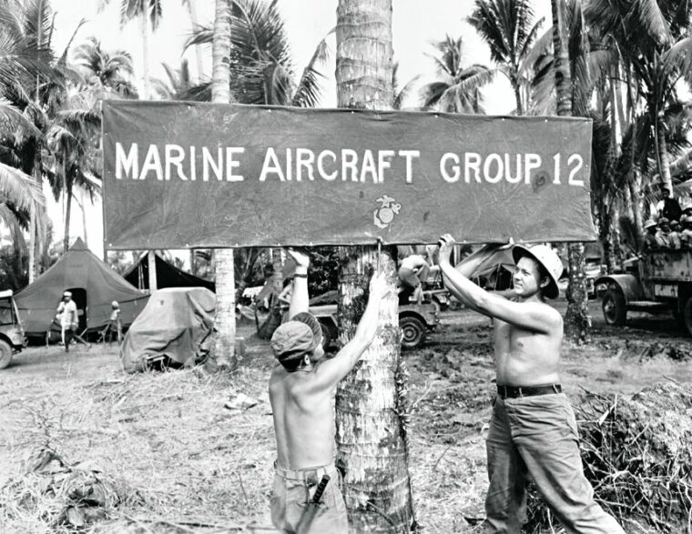 Marines with MAG-12 erect a sign at entrance to the pilot’s camp at Lingayen, January 6, 1945.
