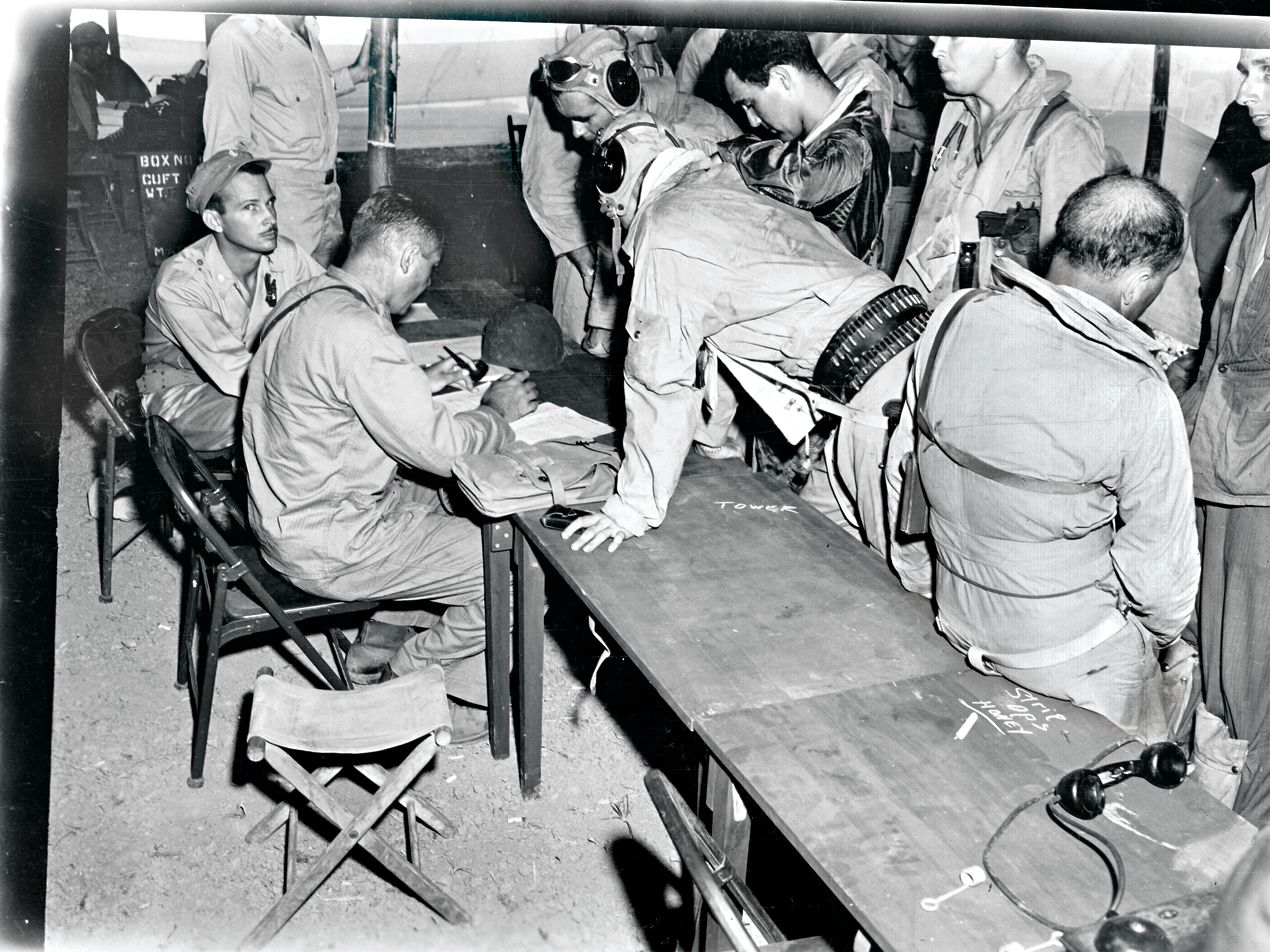 Marine pilots write after-action reports following their first close air support missions of Army troops on Luzon, January 1945.