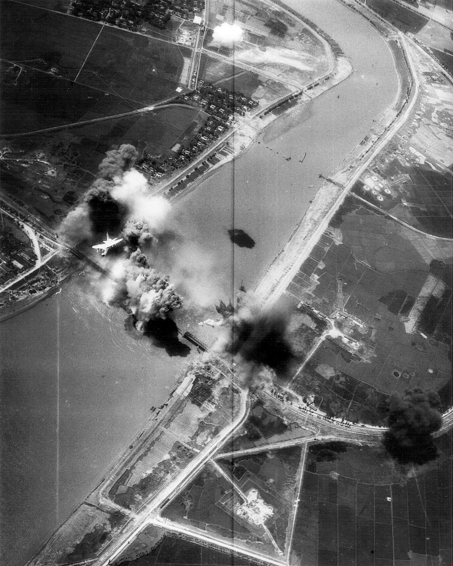 A U.S. Navy A-7E Corsair II from USS Kitty Hawk bombs Hai Duong railway and a highway bridge in North Vietnam.