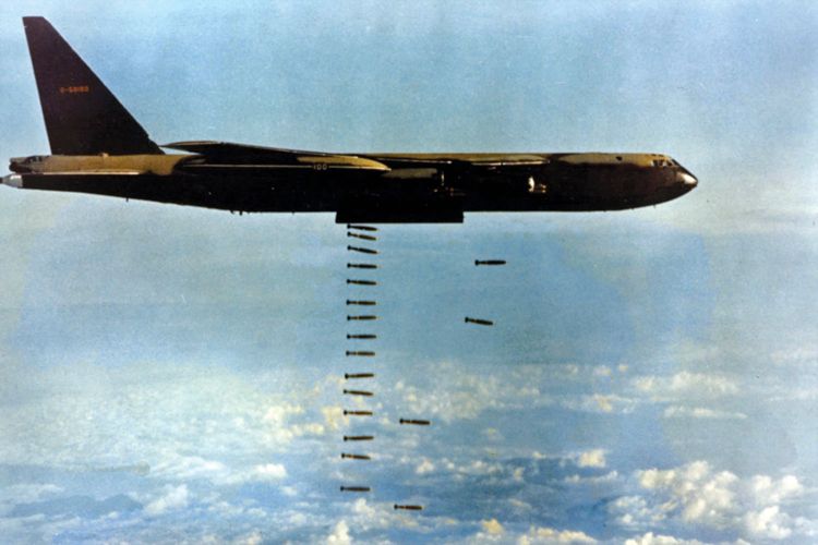 A U.S. B-52 Flying Fortress, left, bombs NVA positions in the Central Highlands.