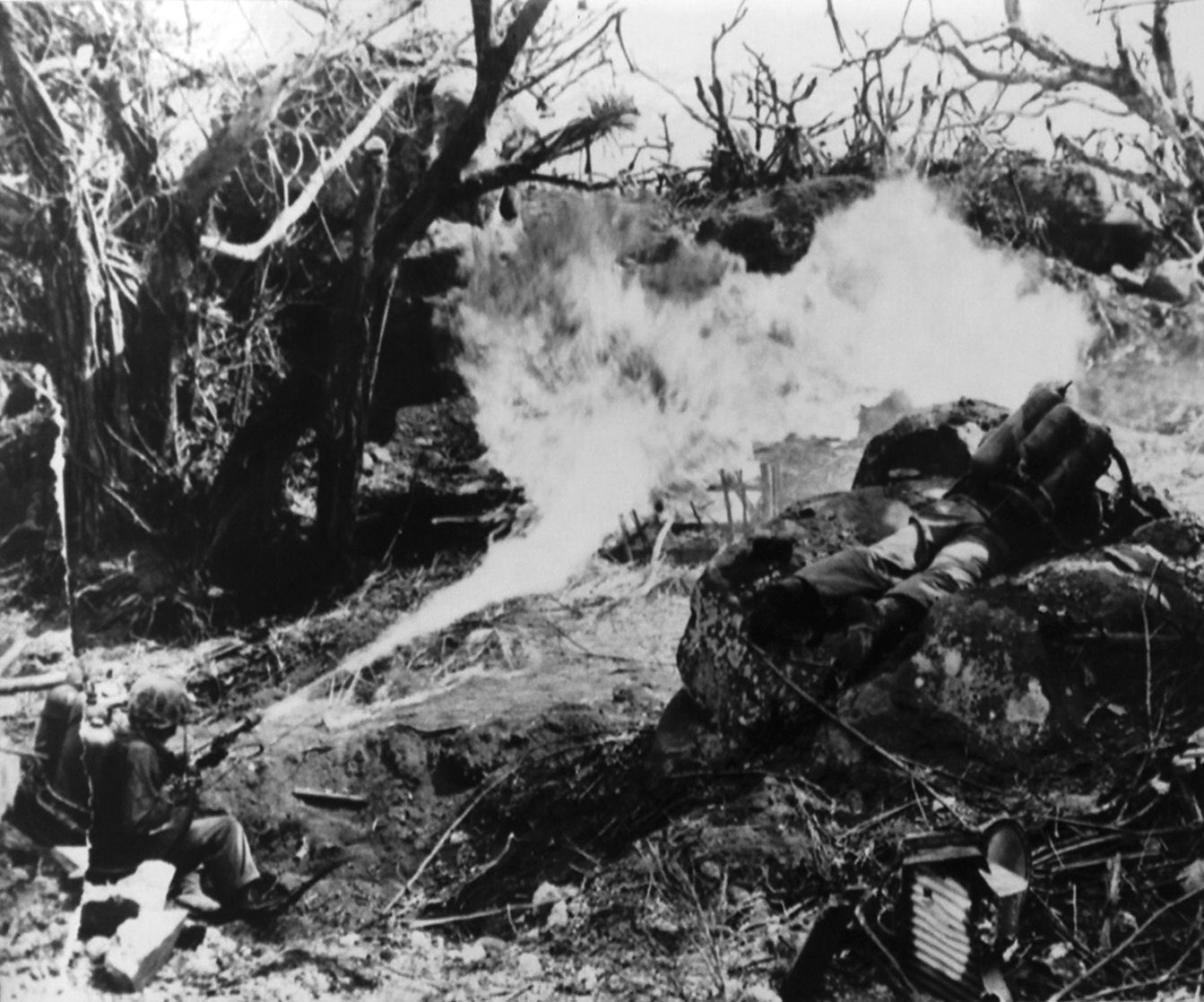 A Marine discharges a flamethrower to clear away thick brush that obscures a path across the islet of Betio. The flamethrowers were essential in the reduction of numerous Japanese strongpoints, burning defenders out of their virtually impenetrable bunkers of steel-reinforced concrete, coconut logs, and sand.