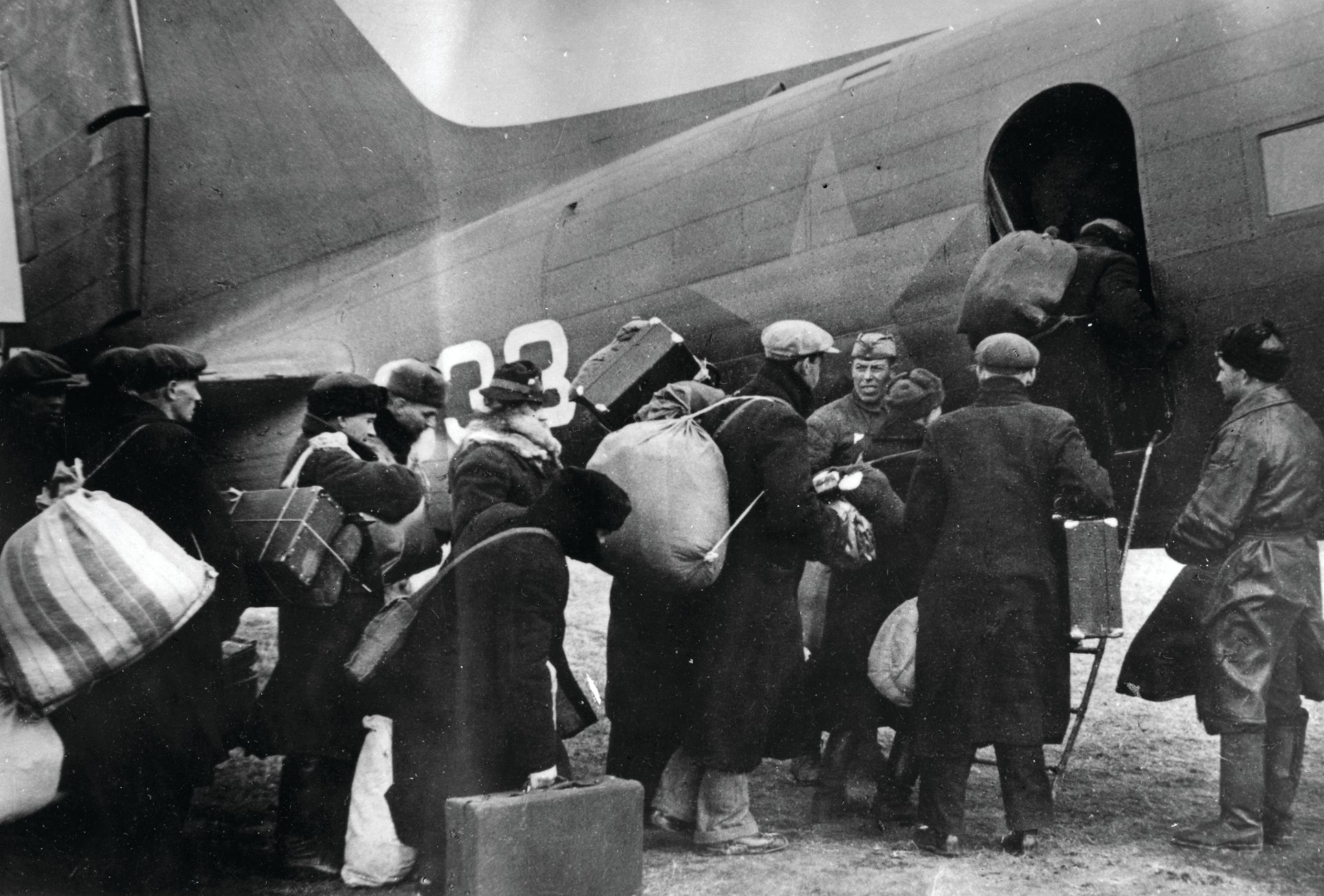 Evacuees line up to depart Leningrad in a PS-84 airplane, the Soviet version of the Douglas DC-3, October 1941.