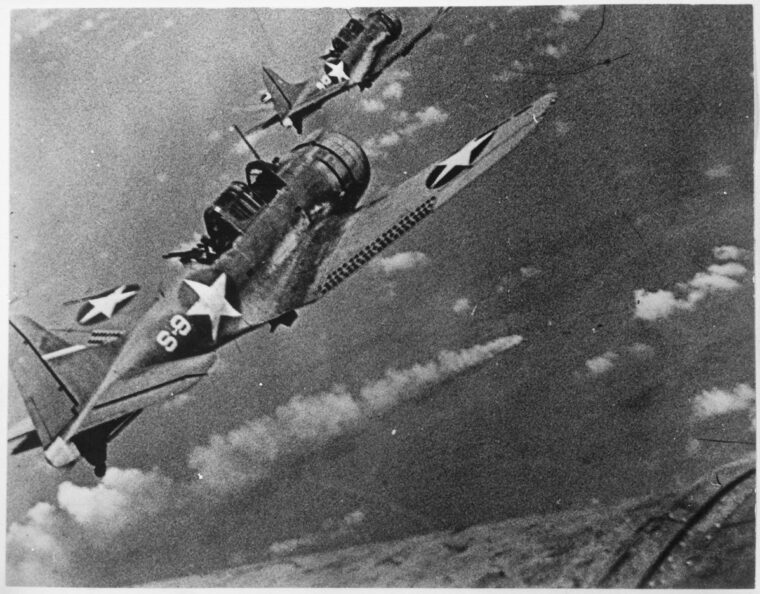 U.S. Navy Douglas SBD-3 Dauntless dive bombers from USS Hornet approach the burning heavy cruiser Mikuma on June 6.