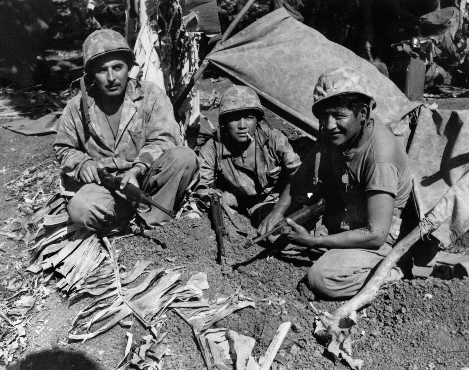 A number of Navajo code talkers and support personnel landed with the first wave of Marines on Saipan in the Marianas in June 1944. Shown from left to right are Corporal Oscar B. Iithma of Gallup, New Mexico; Pfc. Jack Nez of Fort Defiance, Arizona; and Pfc. Carl C. Gorman of Chinle, Arizona.