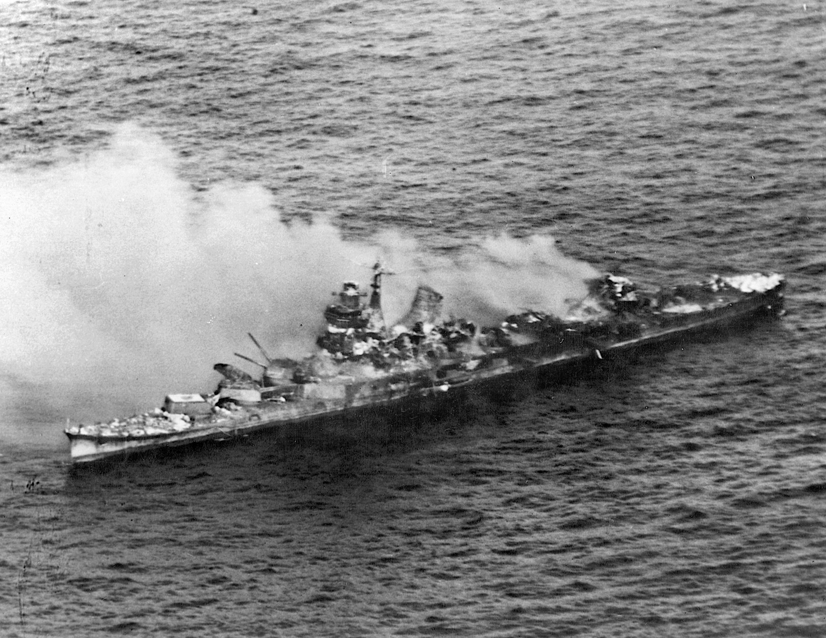 Japanese heavy cruiser Mikuma burns from strikes by Hornet and Enterprise planes. 
