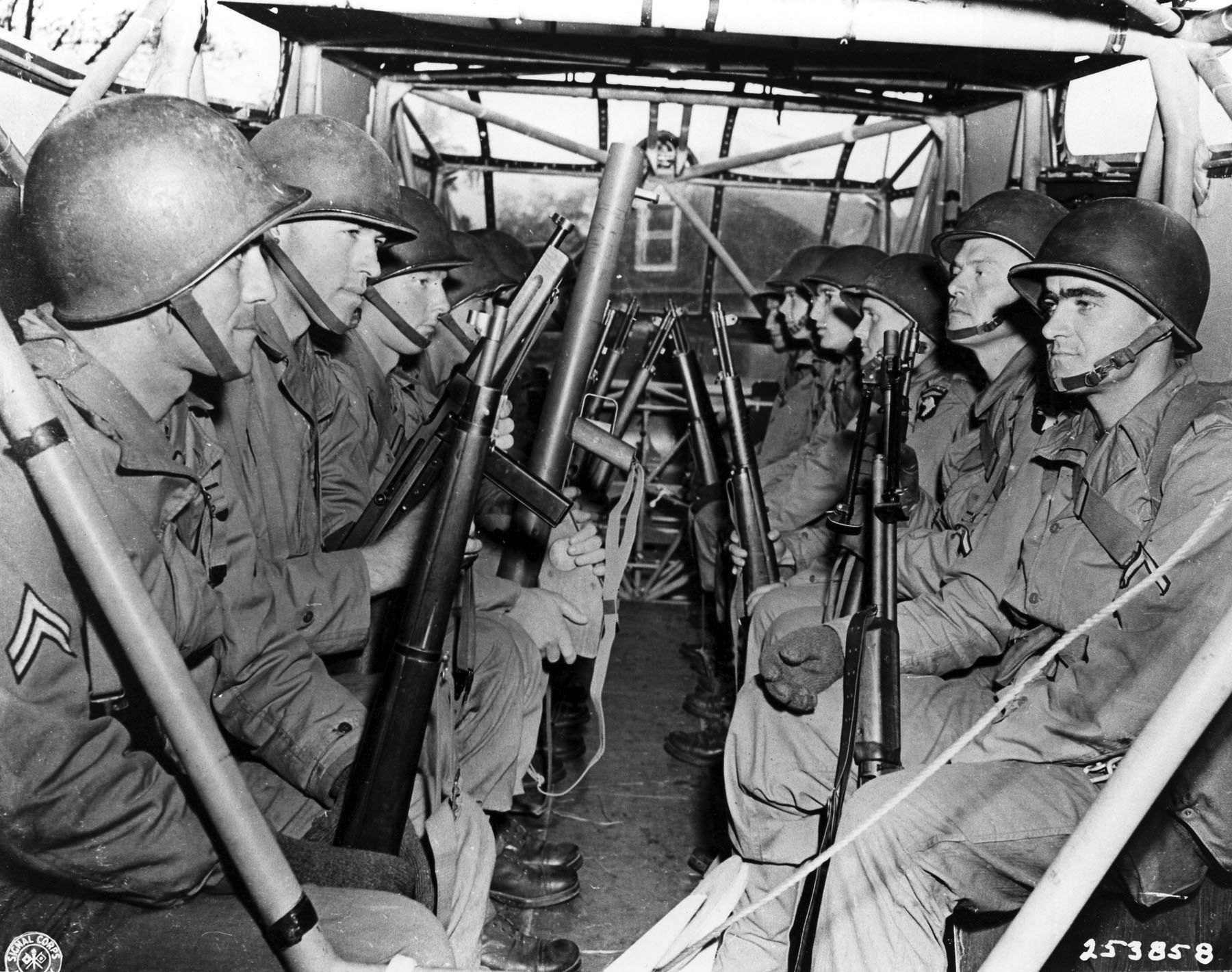 A number of 101st Airborne Division paratroopers sit aboard their Waco glider in early 1944. These troopers carry a variety of weapons, including the Browning Automatic Rifle (BAR), bazooka, Thompson submachine gun, and the M1903 rifle visible in the foreground at left.